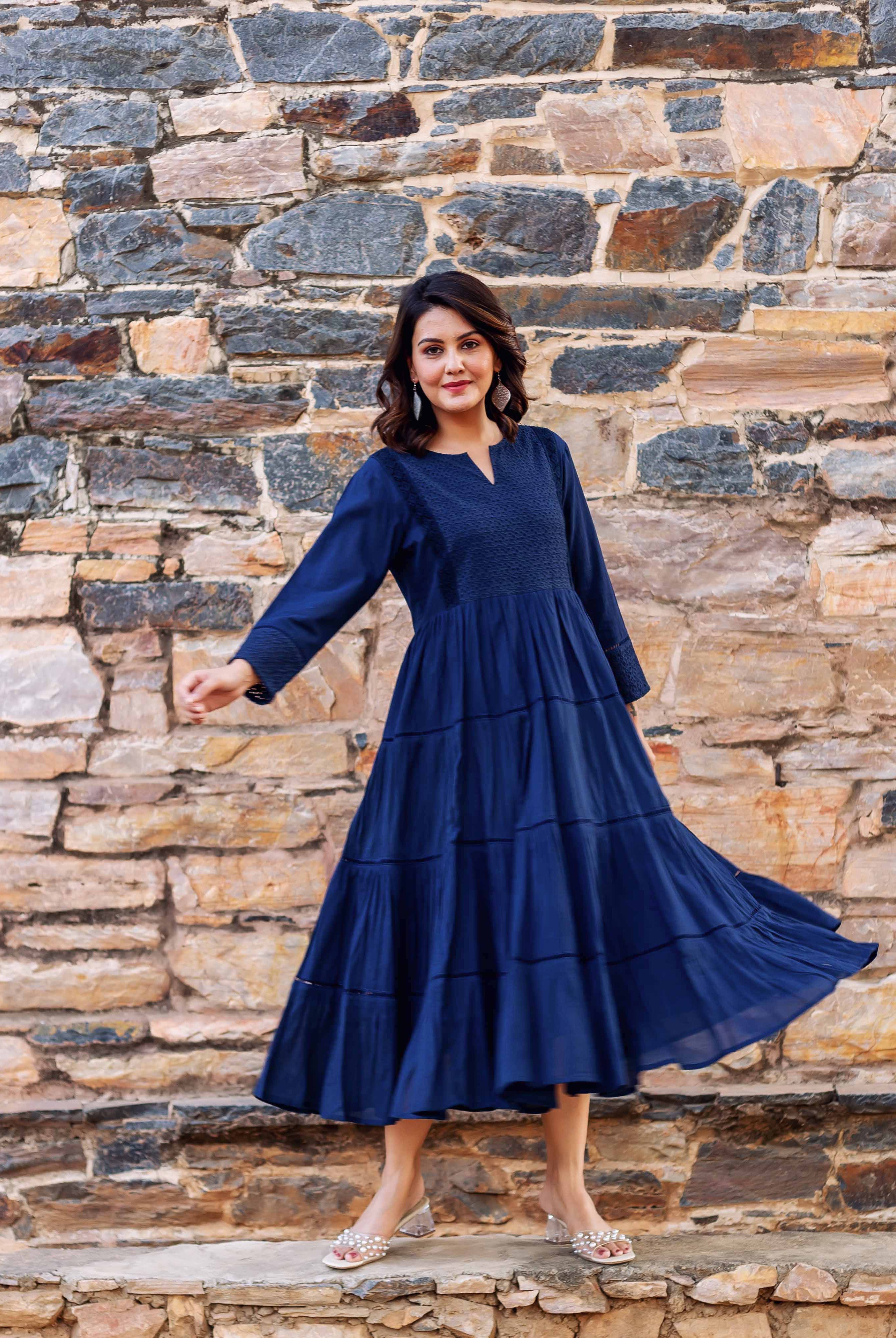 Front: Woman models indigo tiered dress with ethnic pattern and flowing skirt.