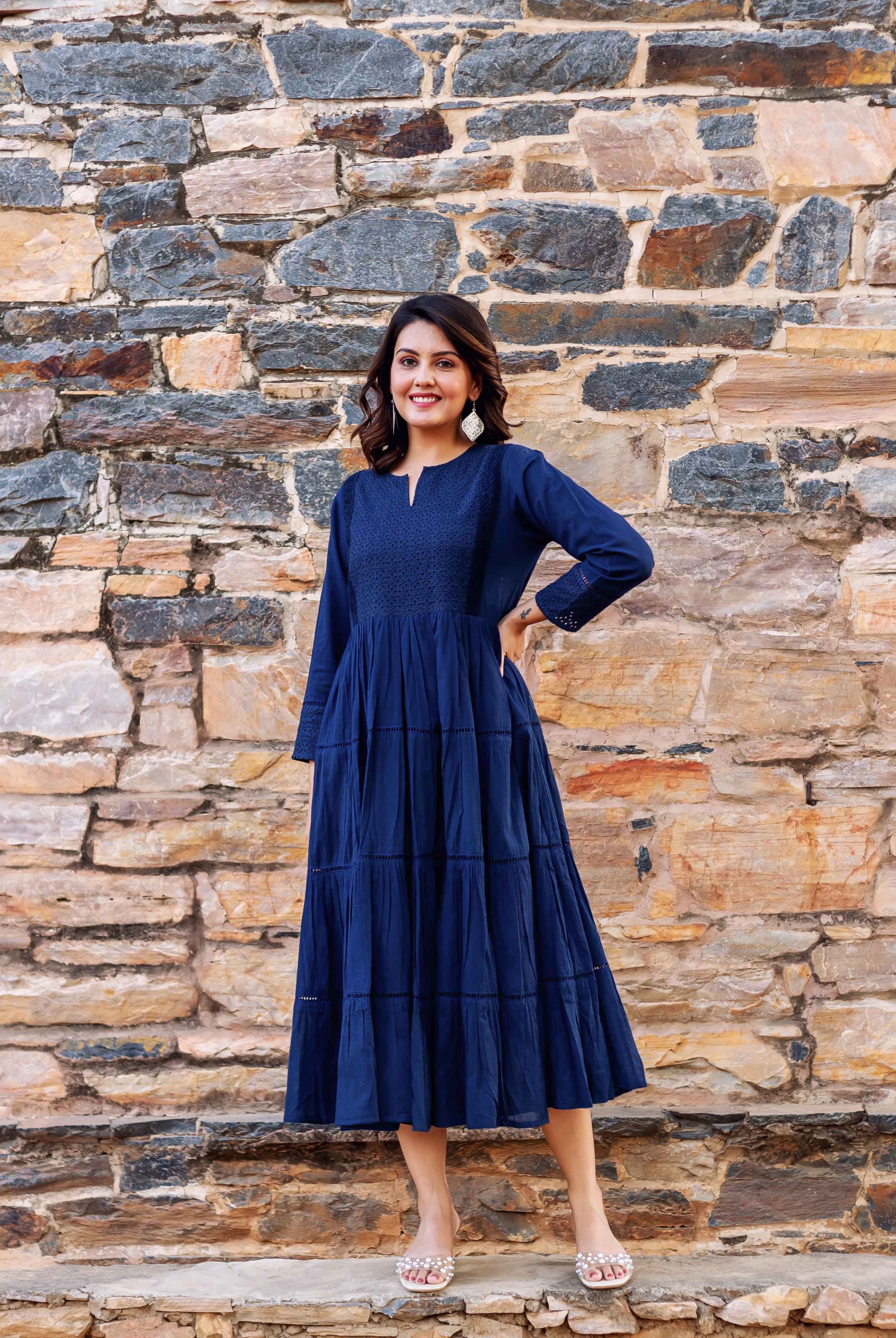 Full look front on model of a tiered indigo dress with embroidered yoke.