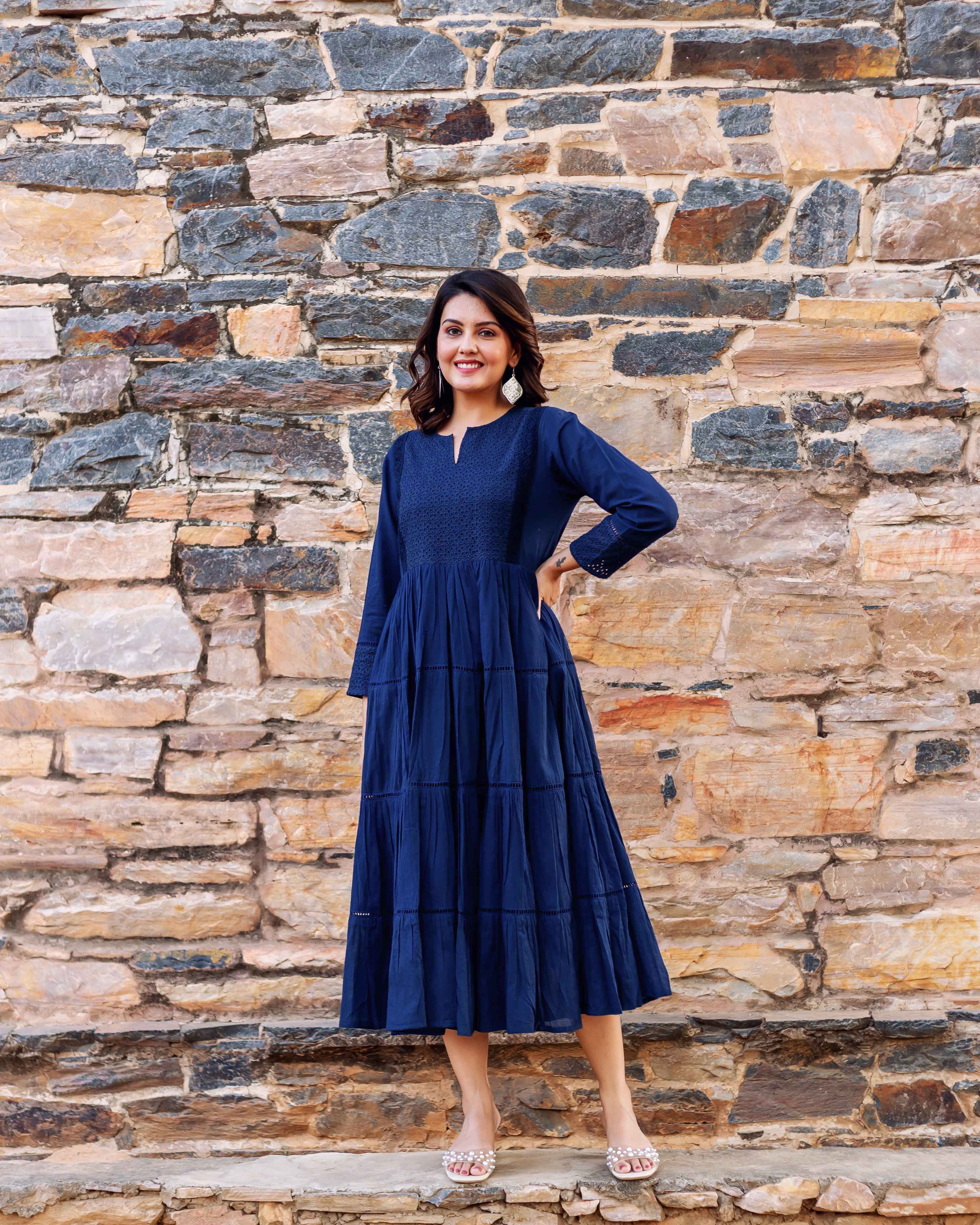 Full look front on model of a tiered indigo dress with embroidered yoke.