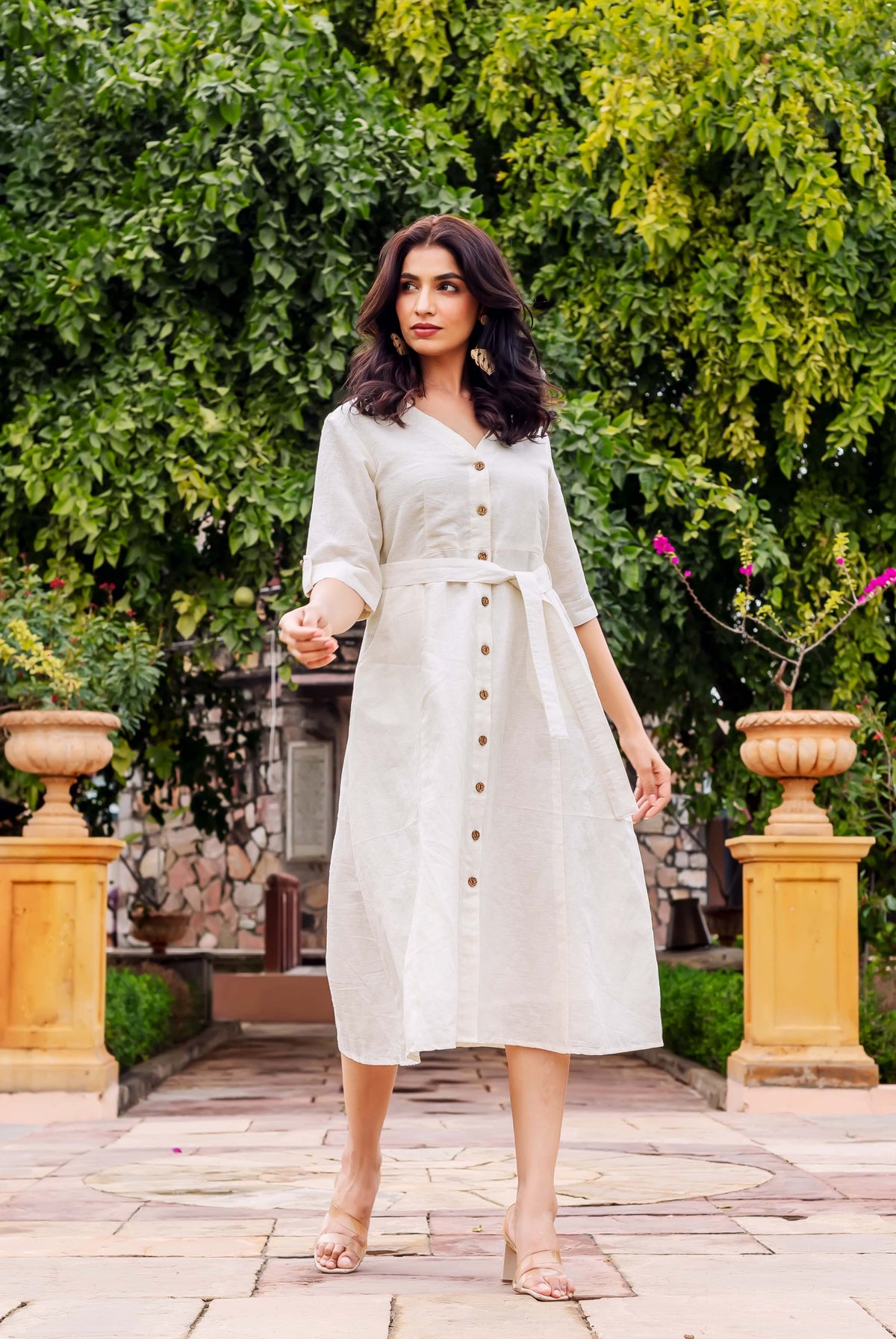 Model in an off-white V-neck button-front linen midi dress with a self-tie belt.
