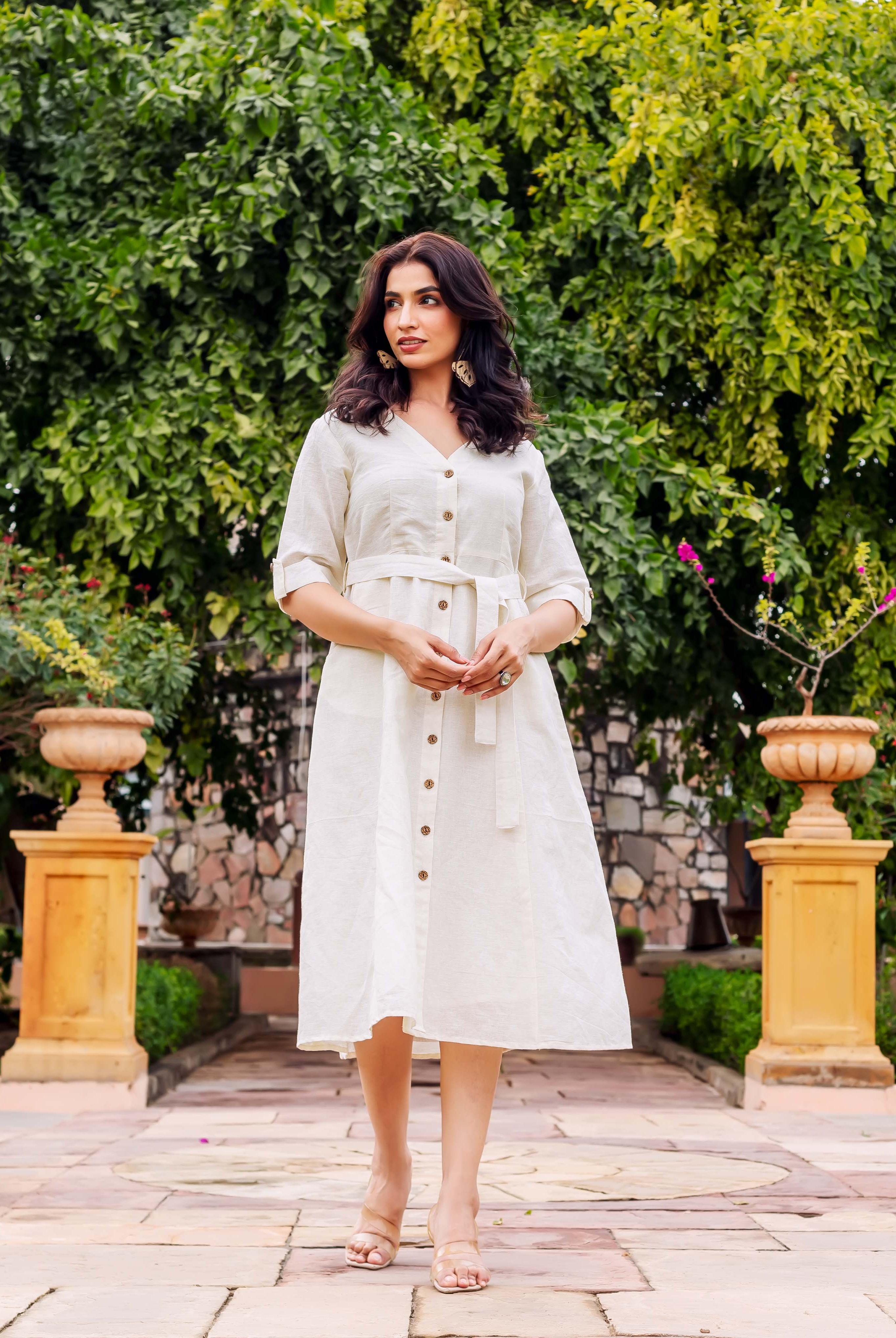 Off-white textured linen midi dress on model, V-neck, button-front, belted, and rolled sleeves.