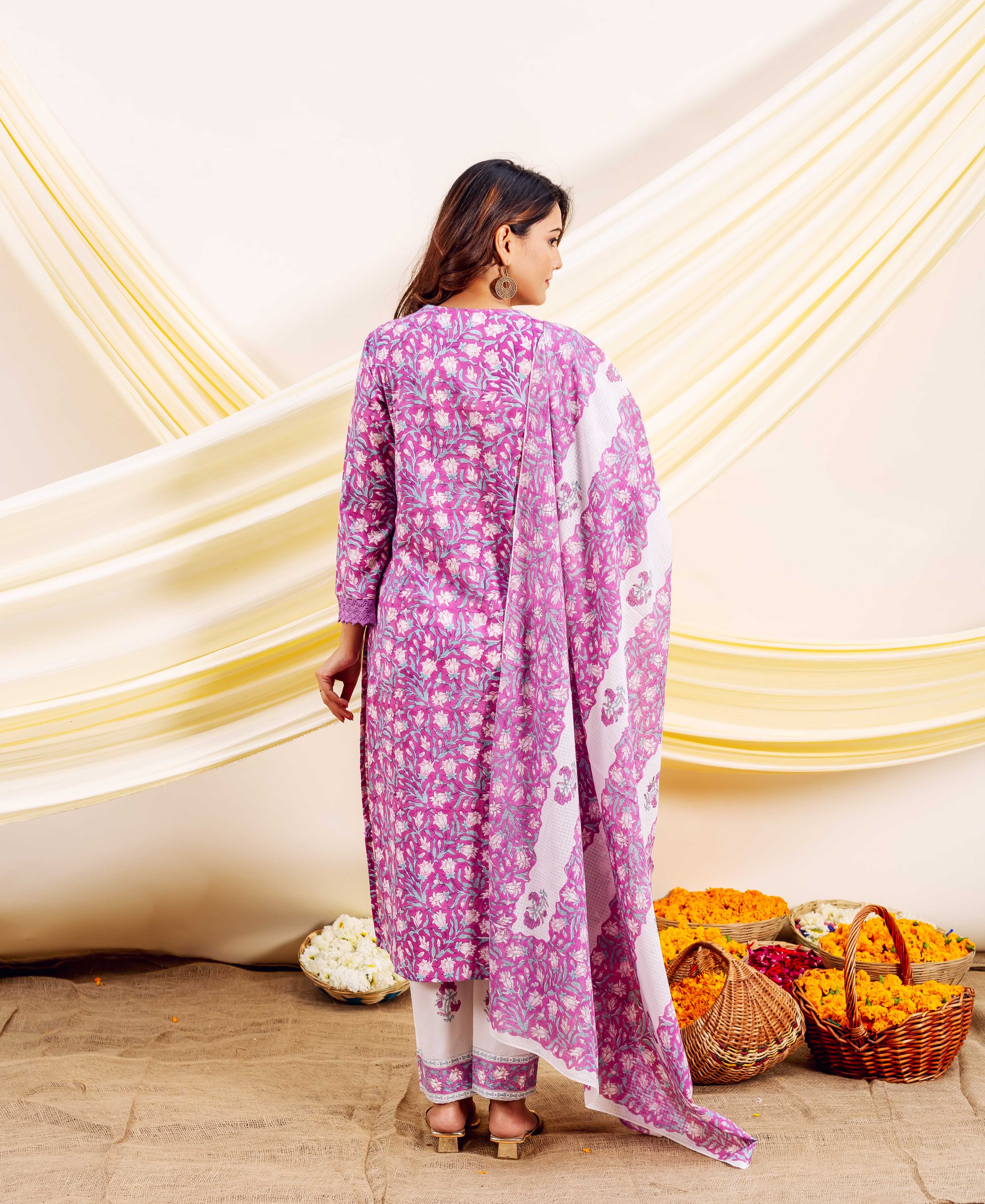 Model from behind in a purple and white floral block-printed ethnic suit.