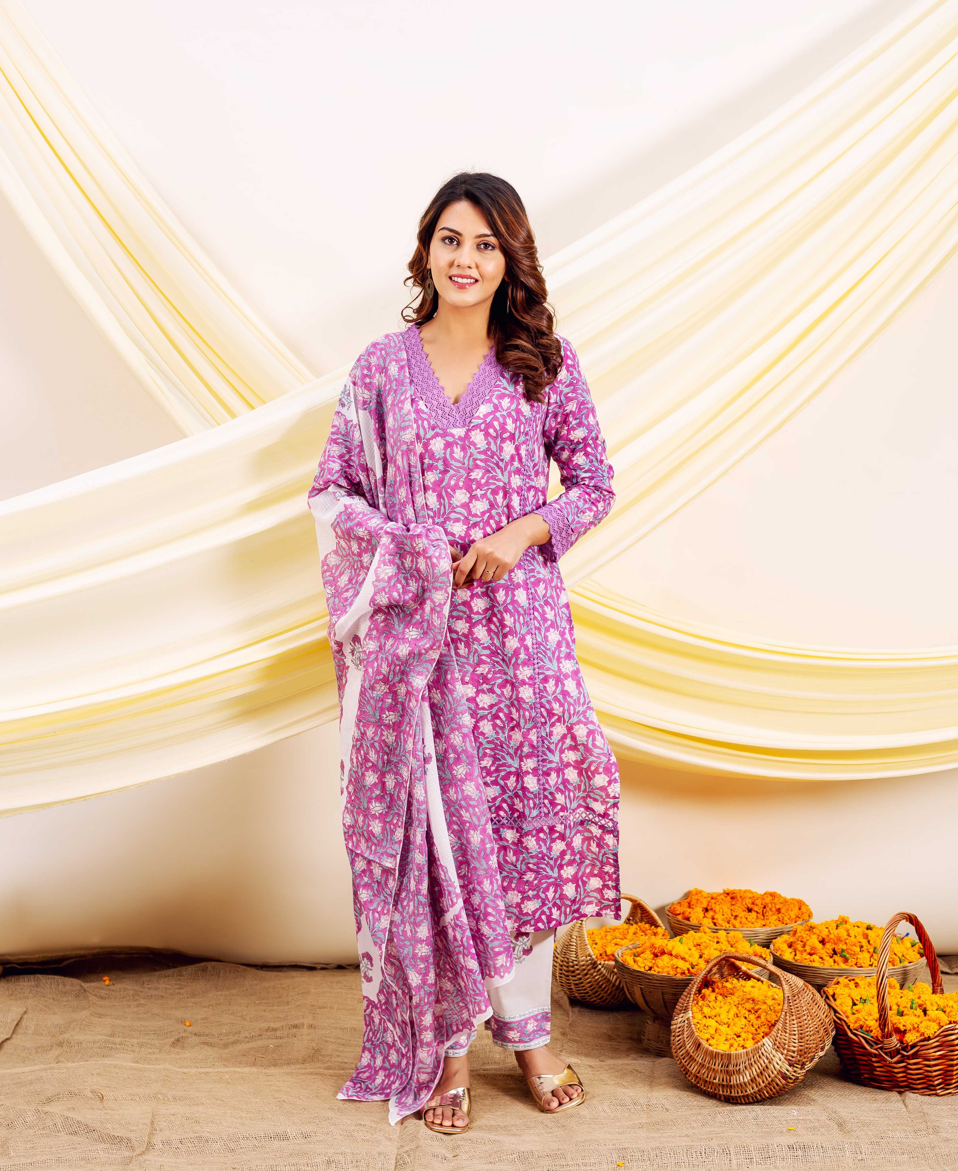 Full-length model wears a purple and white floral block-printed kurta set with dupatta.