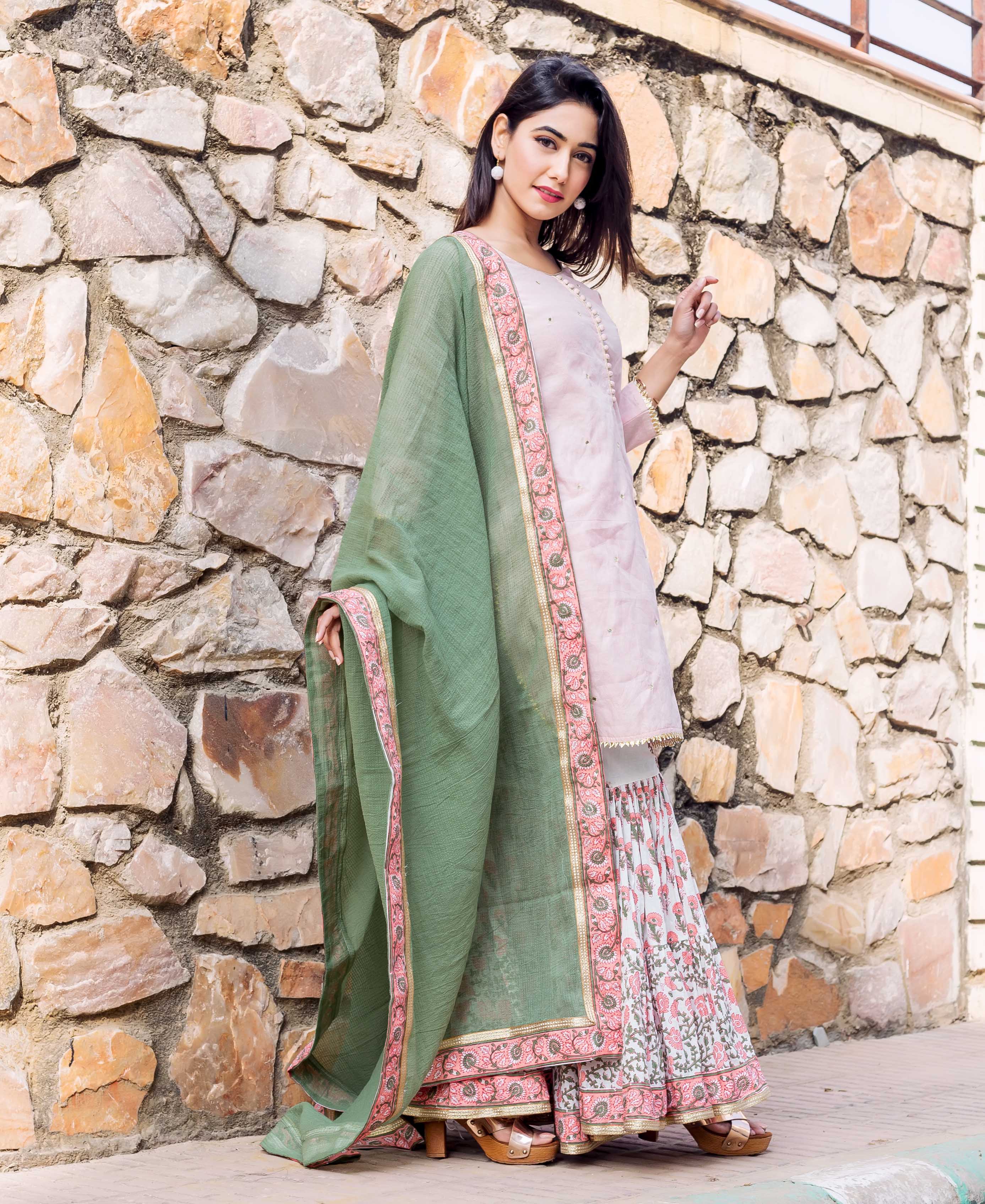 Model showcases a light green Kota Doria dupatta with a pink and gold block-printed border.