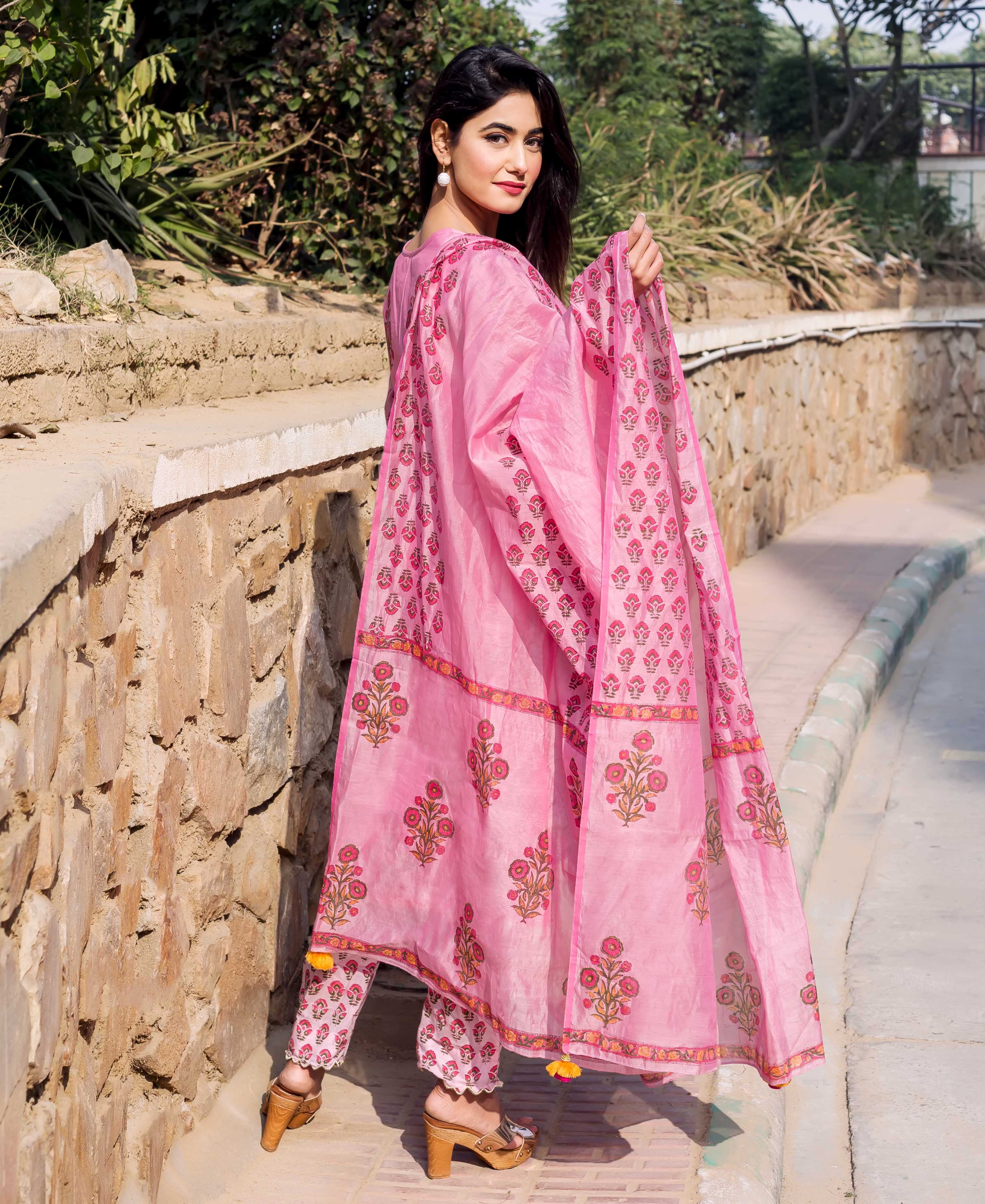 Model in pink Chanderi hand block printed dupatta, featuring floral motifs, looking over shoulder.