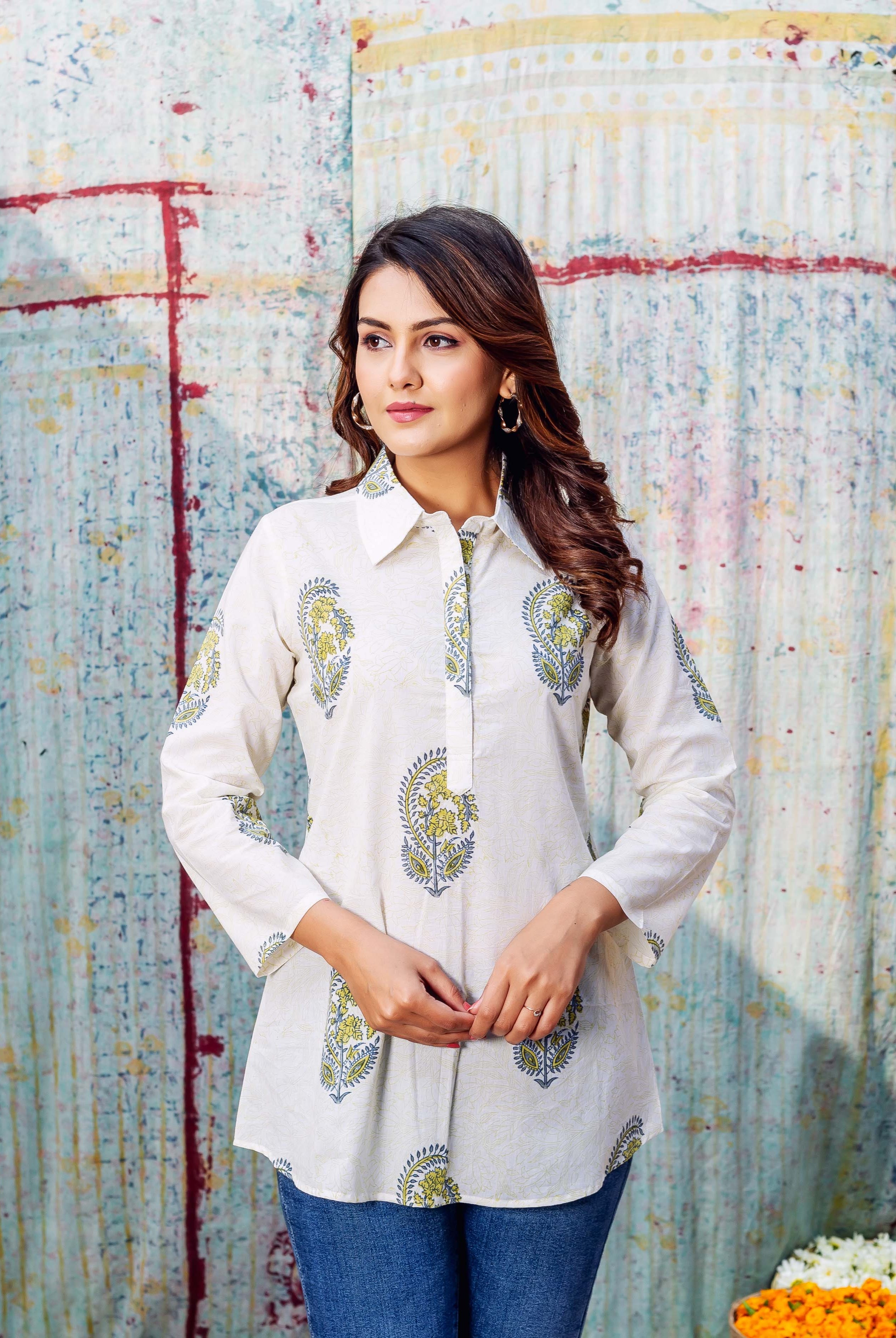 Model wears an ivory hand-printed top with green and blue stylized paisley motifs.