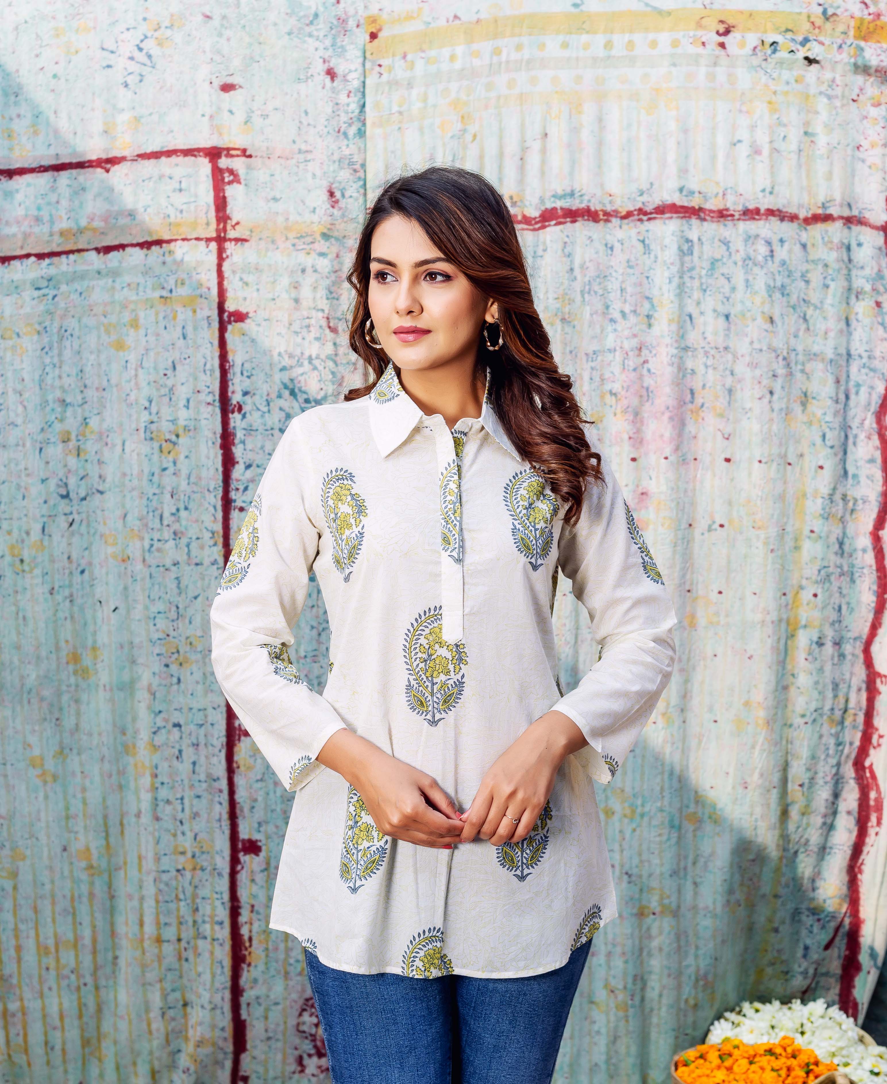 Model wears an ivory hand-printed top with green and blue stylized paisley motifs.