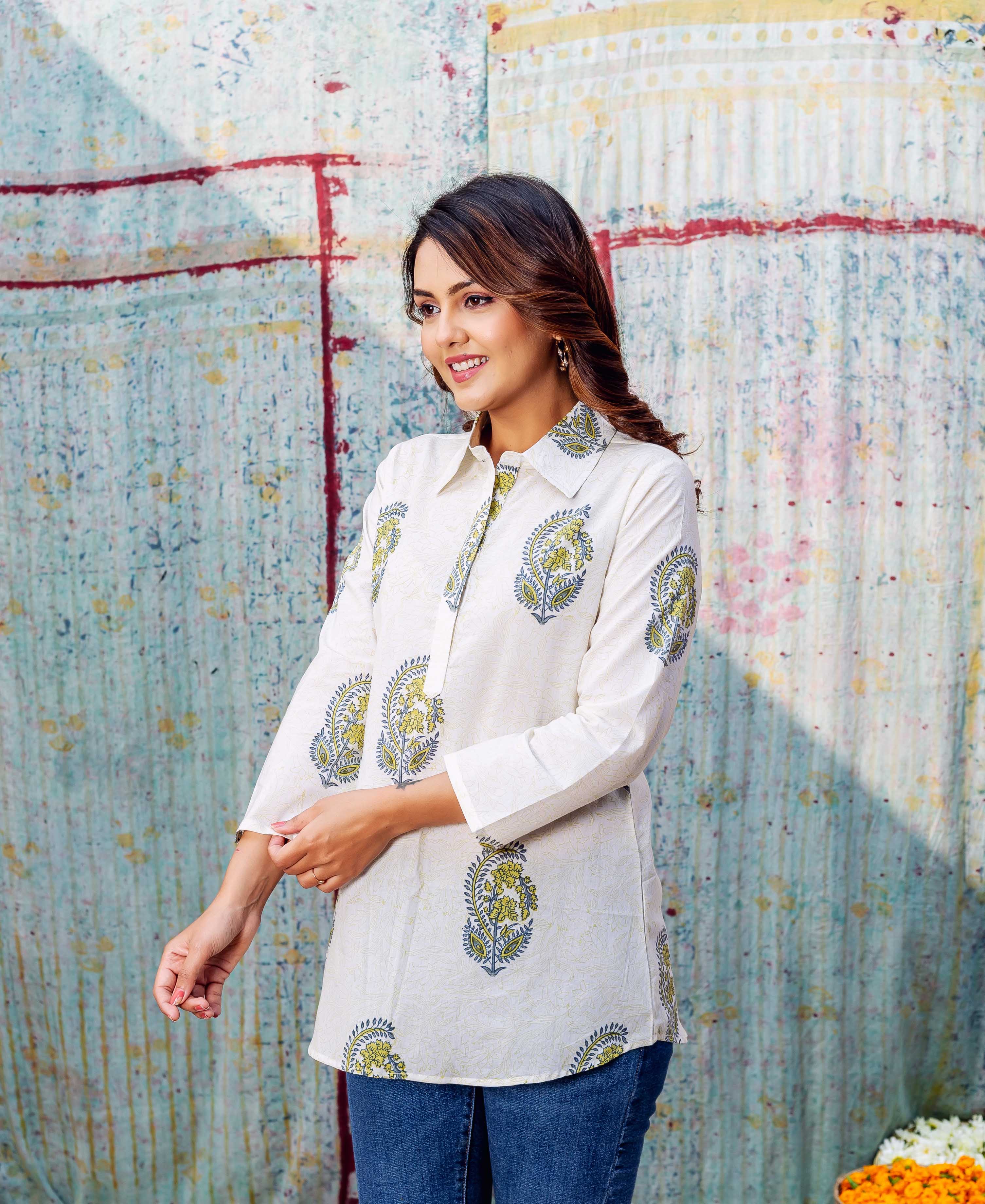 Smiling model in an ivory top featuring green and blue scattered floral hand-block prints.