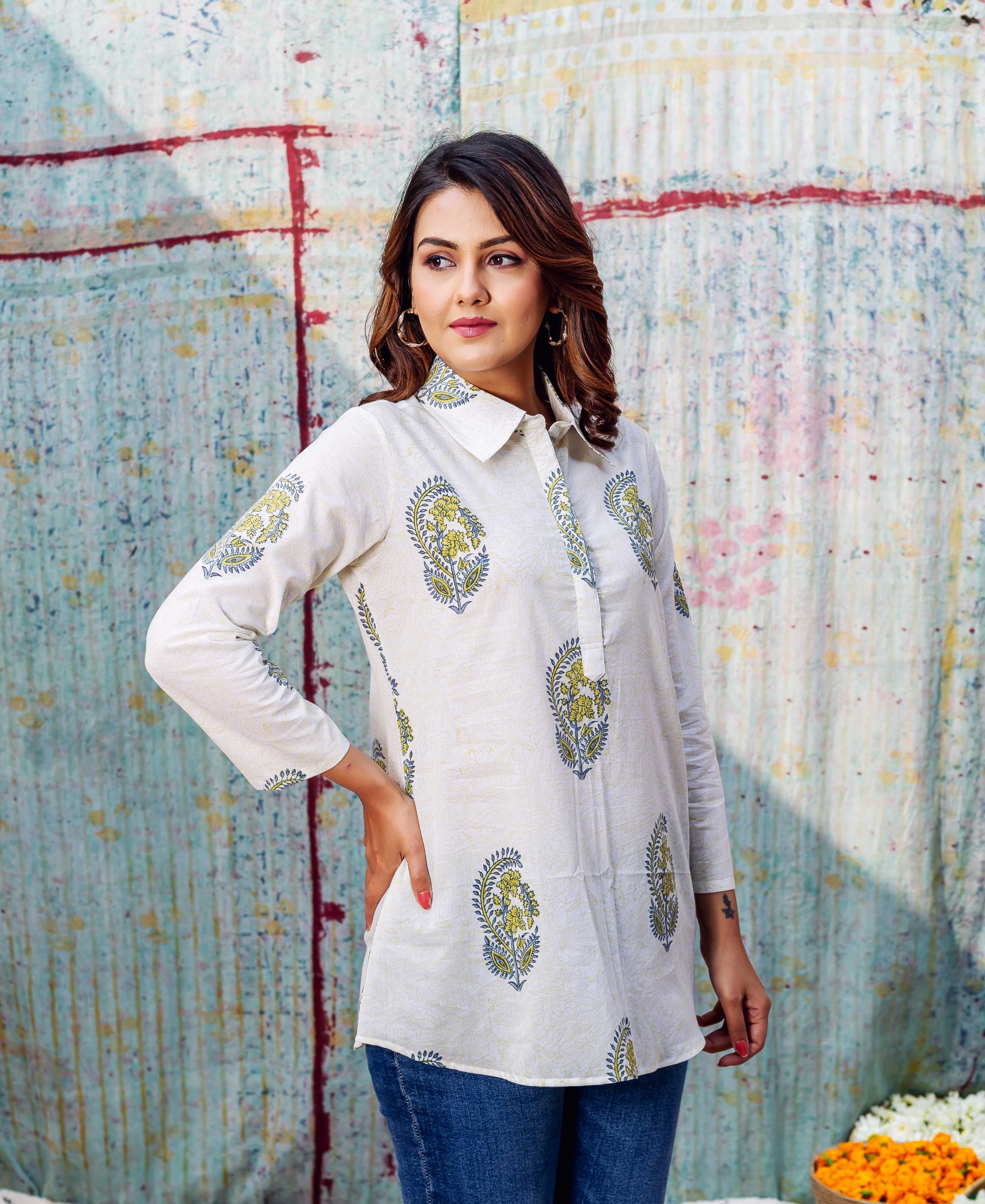 Model in an ivory hand-block-printed top with green and blue paisley motifs.