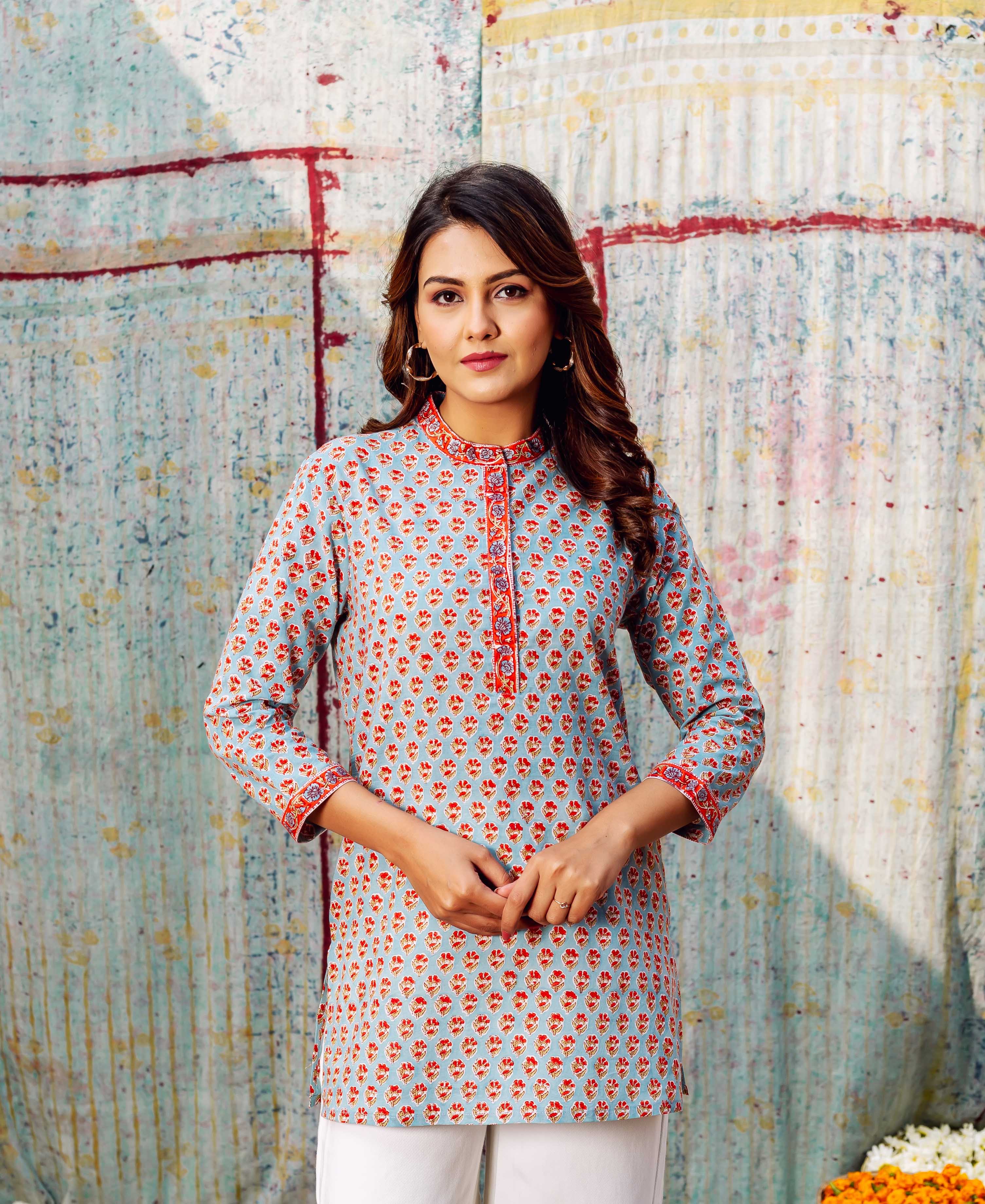 Front view of model wearing light blue top with ashen orange hand-block printed booti.