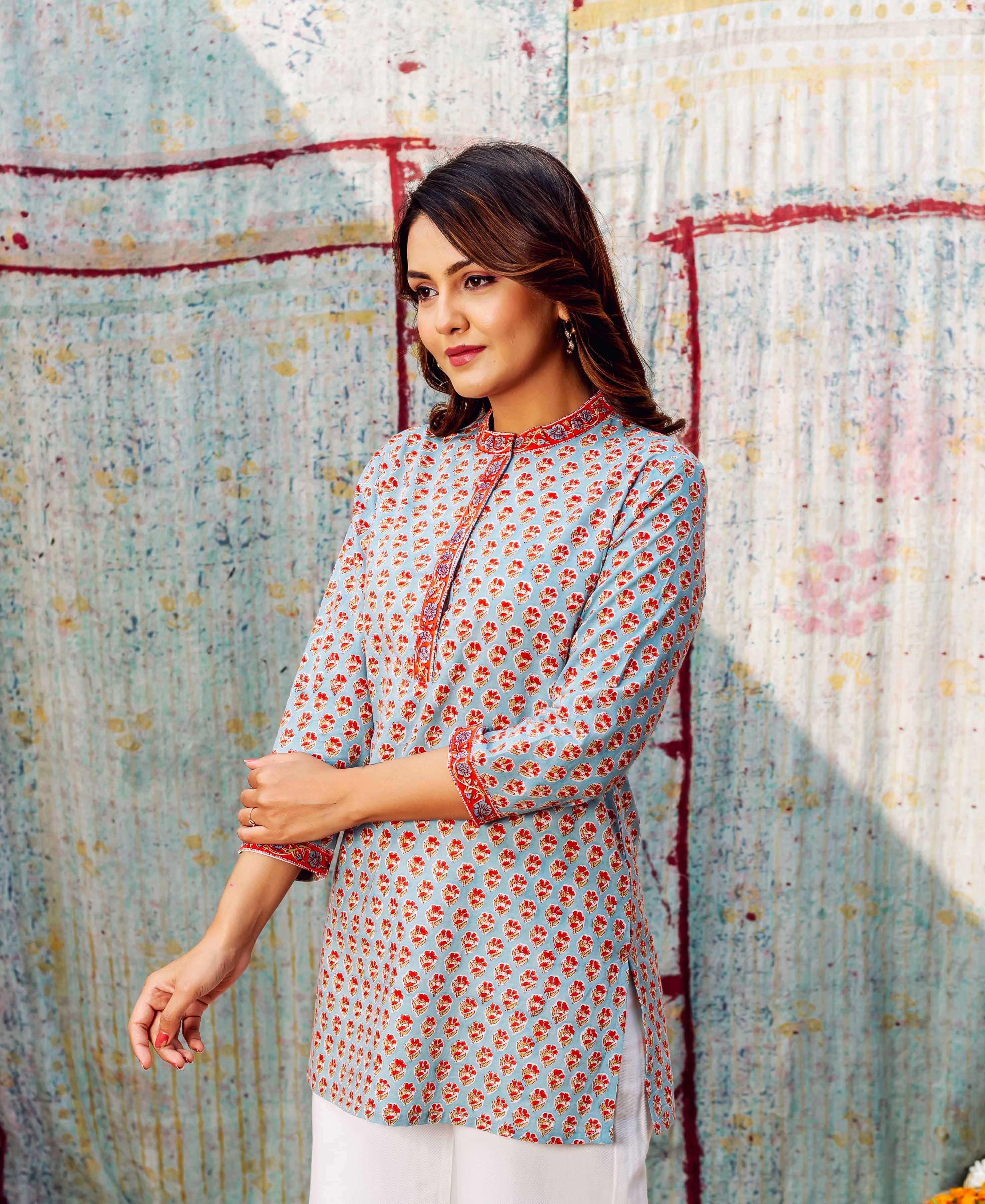 Side-angle view of model in light blue tunic with ashen orange booti print.
