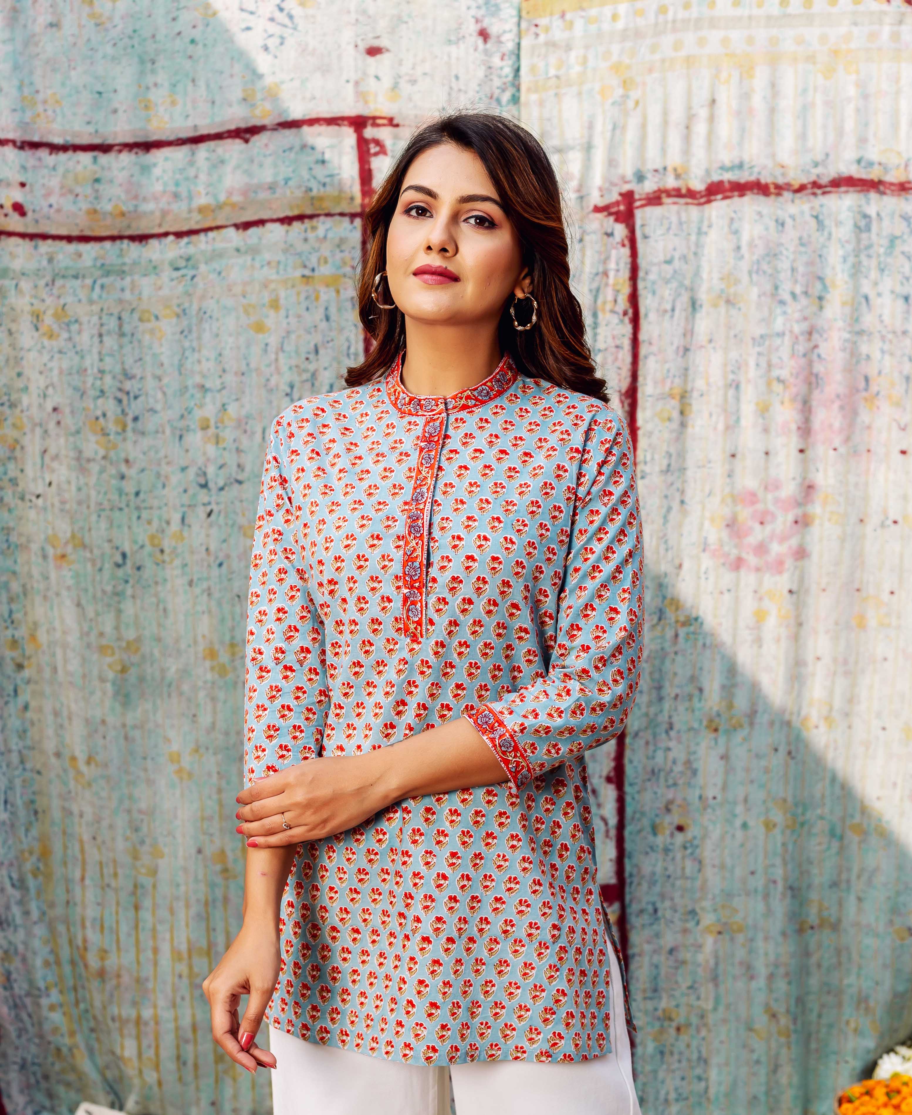 Model in a light blue tunic with all-over orange booti hand-block print.