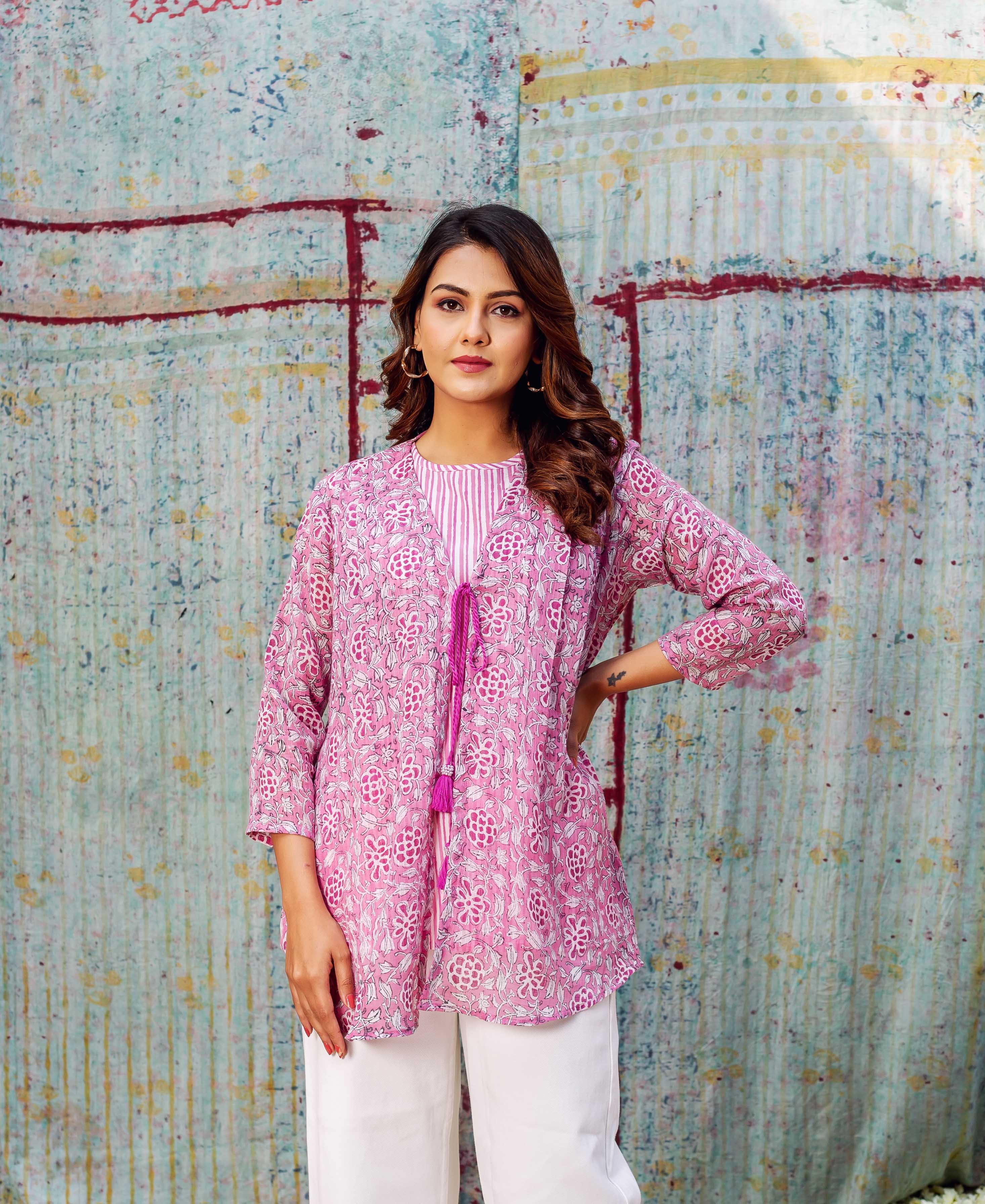 Front view of model wearing a blush pink hand-block-printed floral layered top with white bottoms.