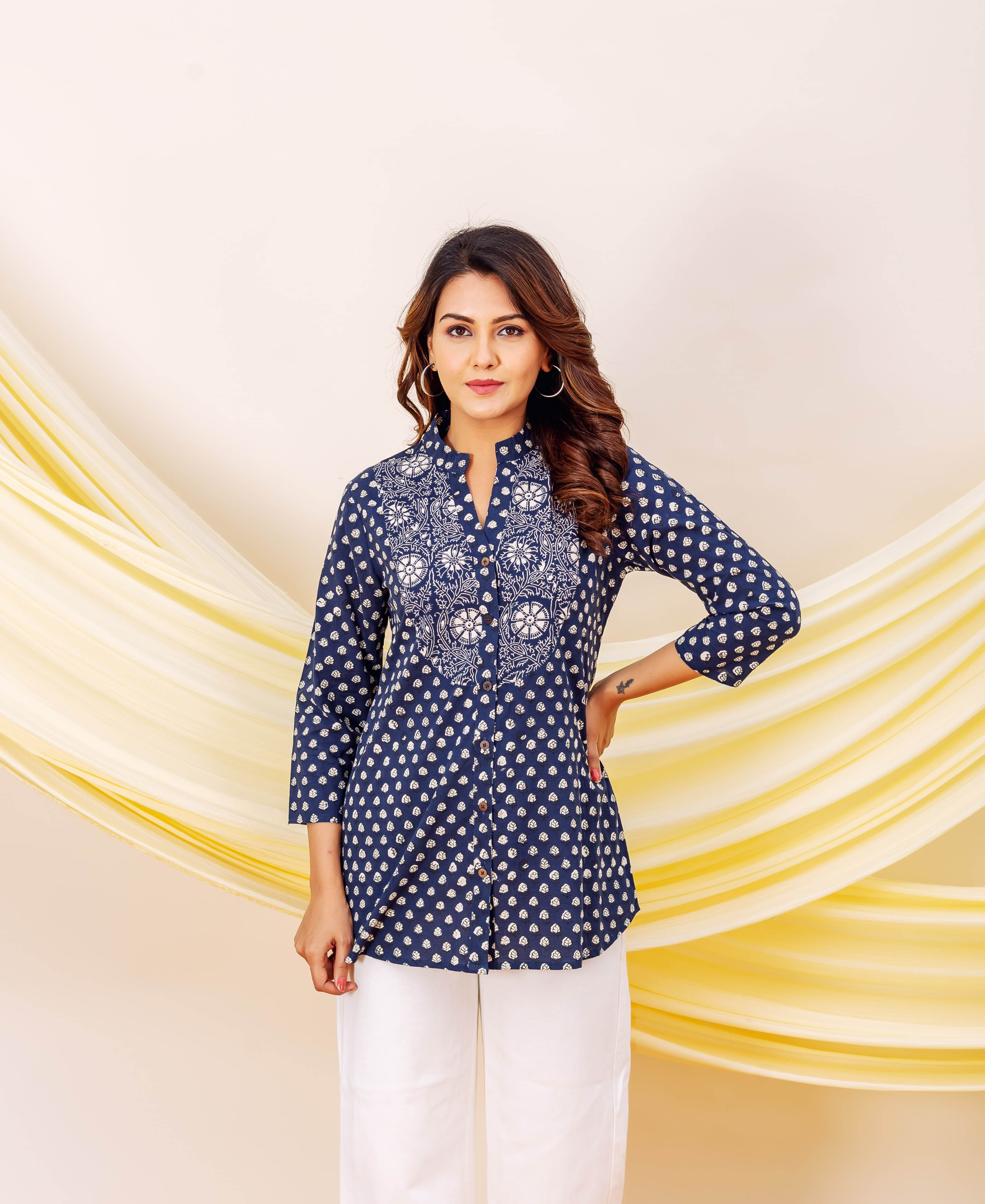 Front view model in indigo blue booti print top with elaborate white yoke, white pants.