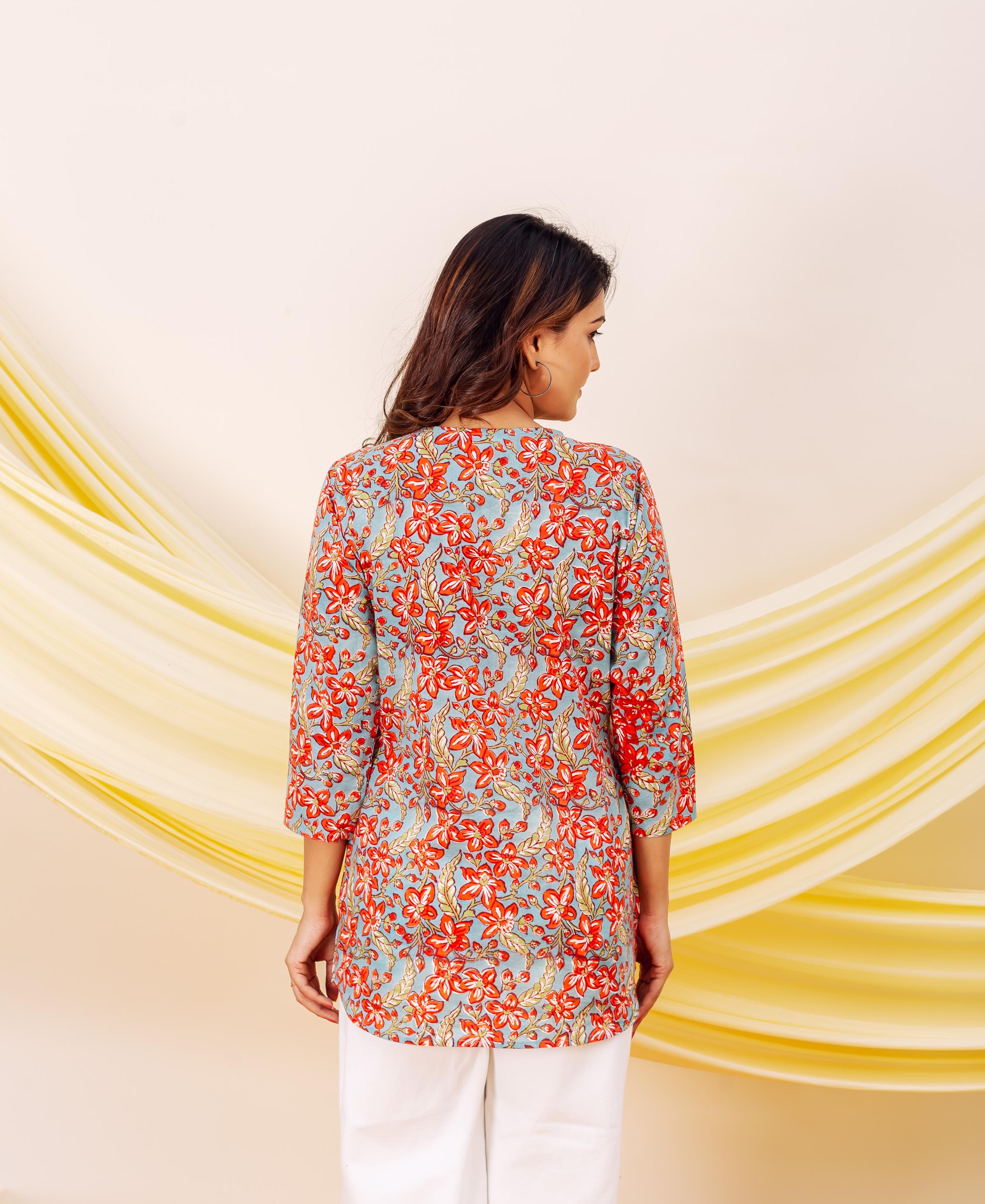 Back view of model in a light blue cotton top with crimson bloom print.
