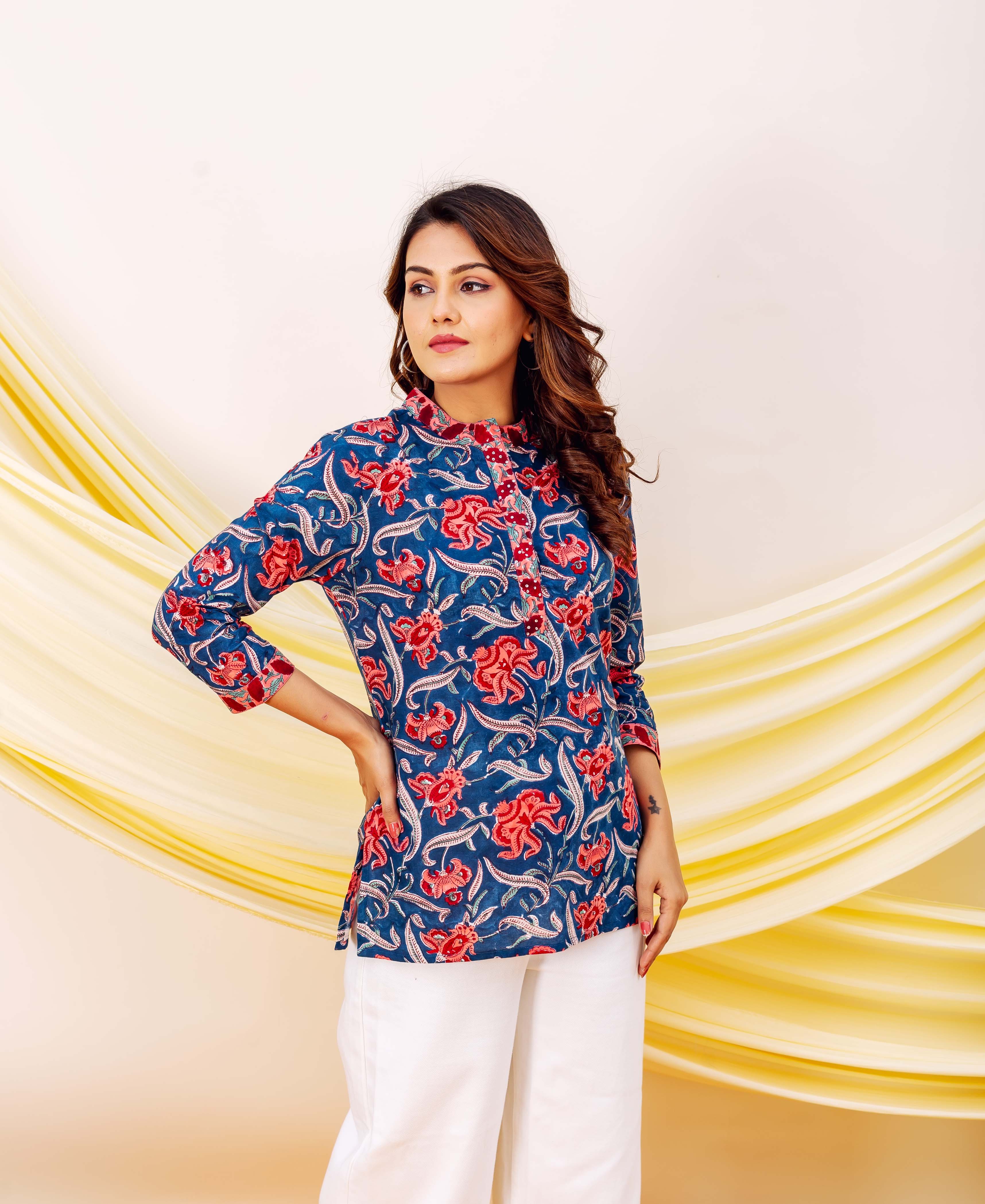 Blue hand-block print tunic with red floral patterns on a model wearing white pants.