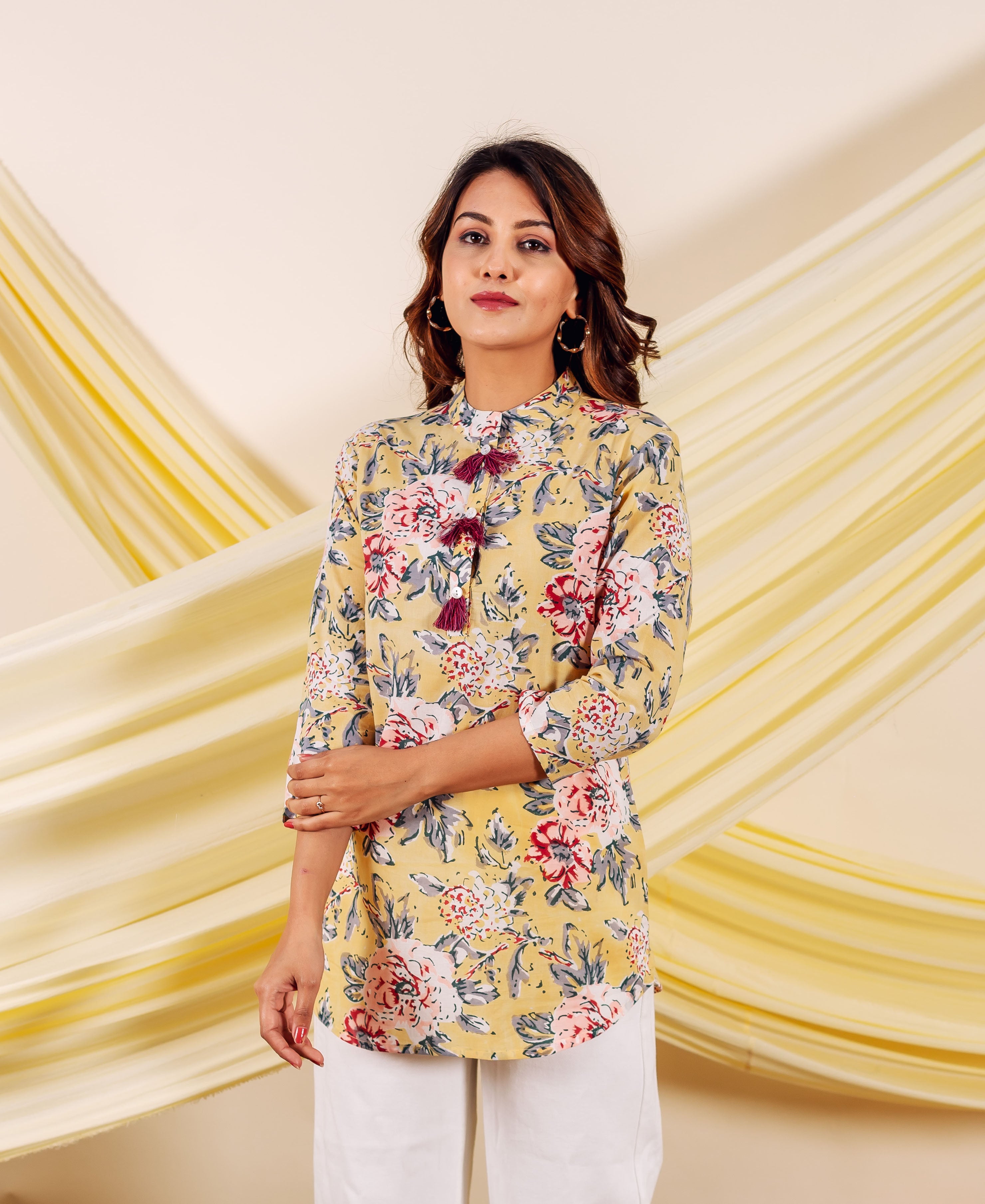 Front-facing model wearing a yellow floral hand-block printed cotton top with tassels.