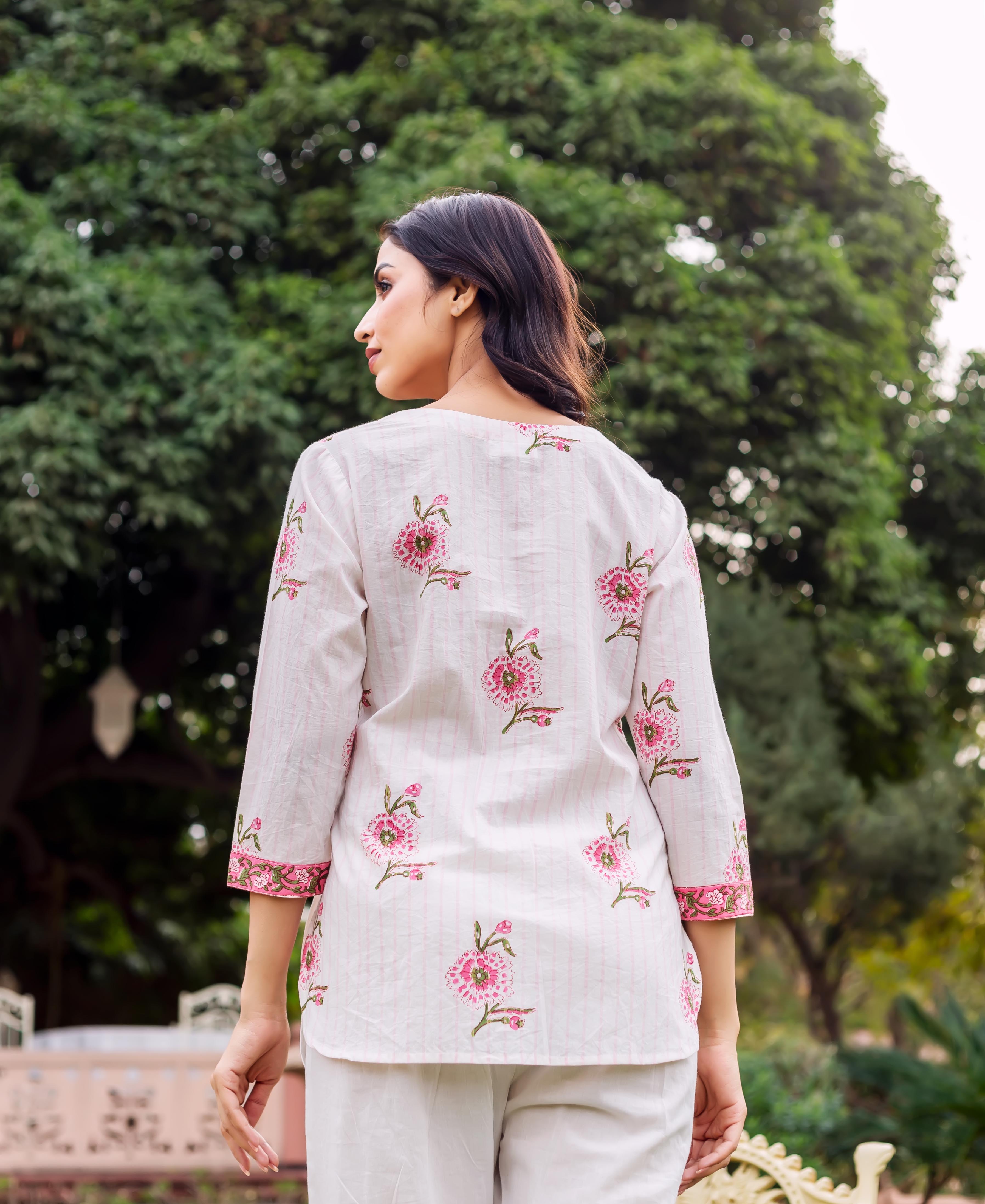 Back view of woman in white tunic with pink floral hand-block print and cuffed sleeves.
