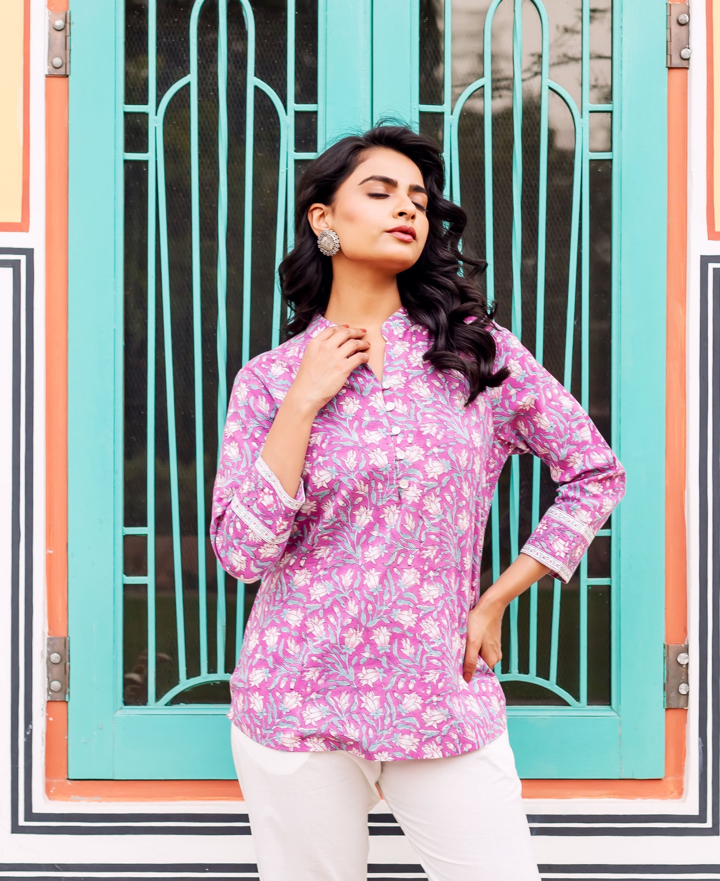 Front view of a model wearing a floral purple cotton tunic with white and green patterns.