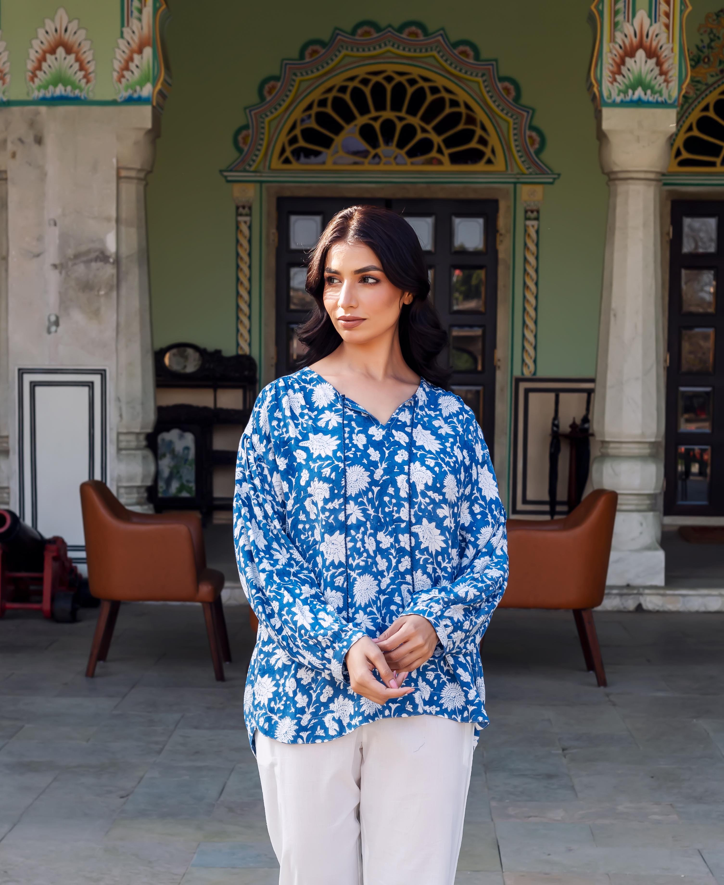 Model wearing a blue hand-block-printed tunic with white floral pattern and white pants.