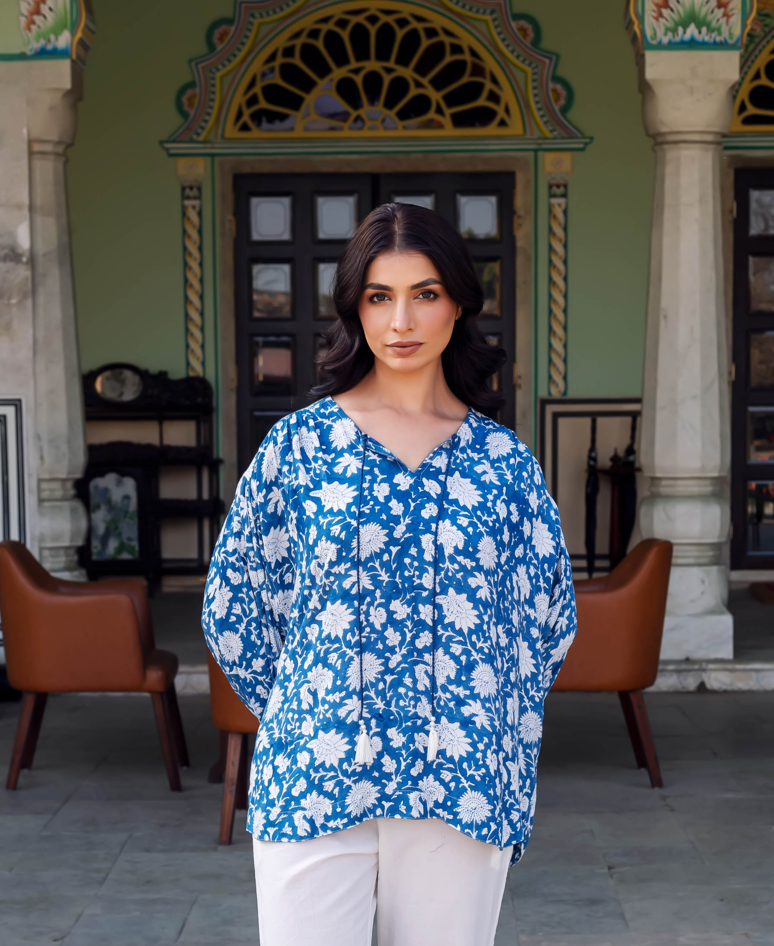 Waist-up shot of a model wearing a blue and white hand-block-printed floral tunic.