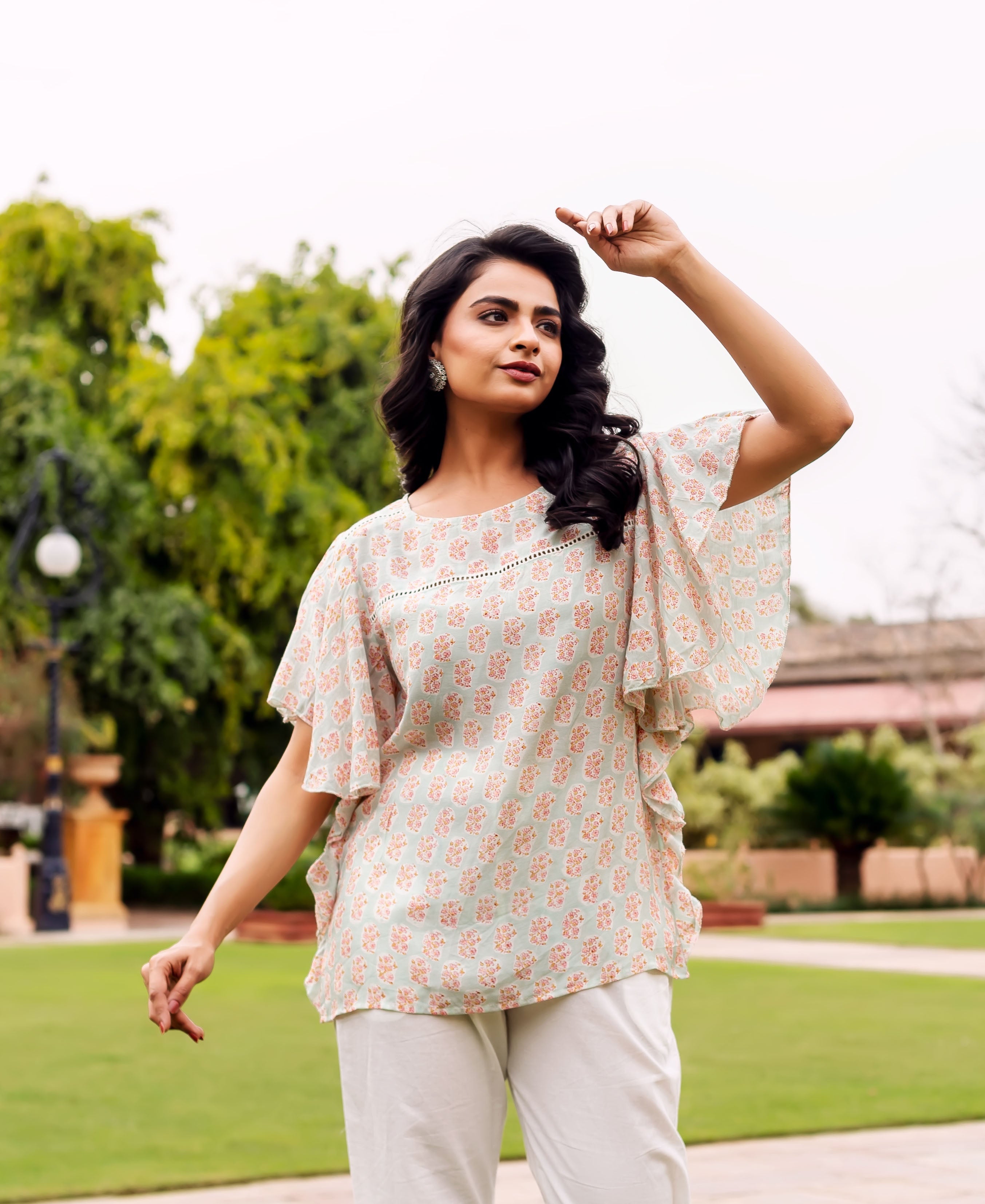 Front full look of model in mint green block printed tunic with white pants.