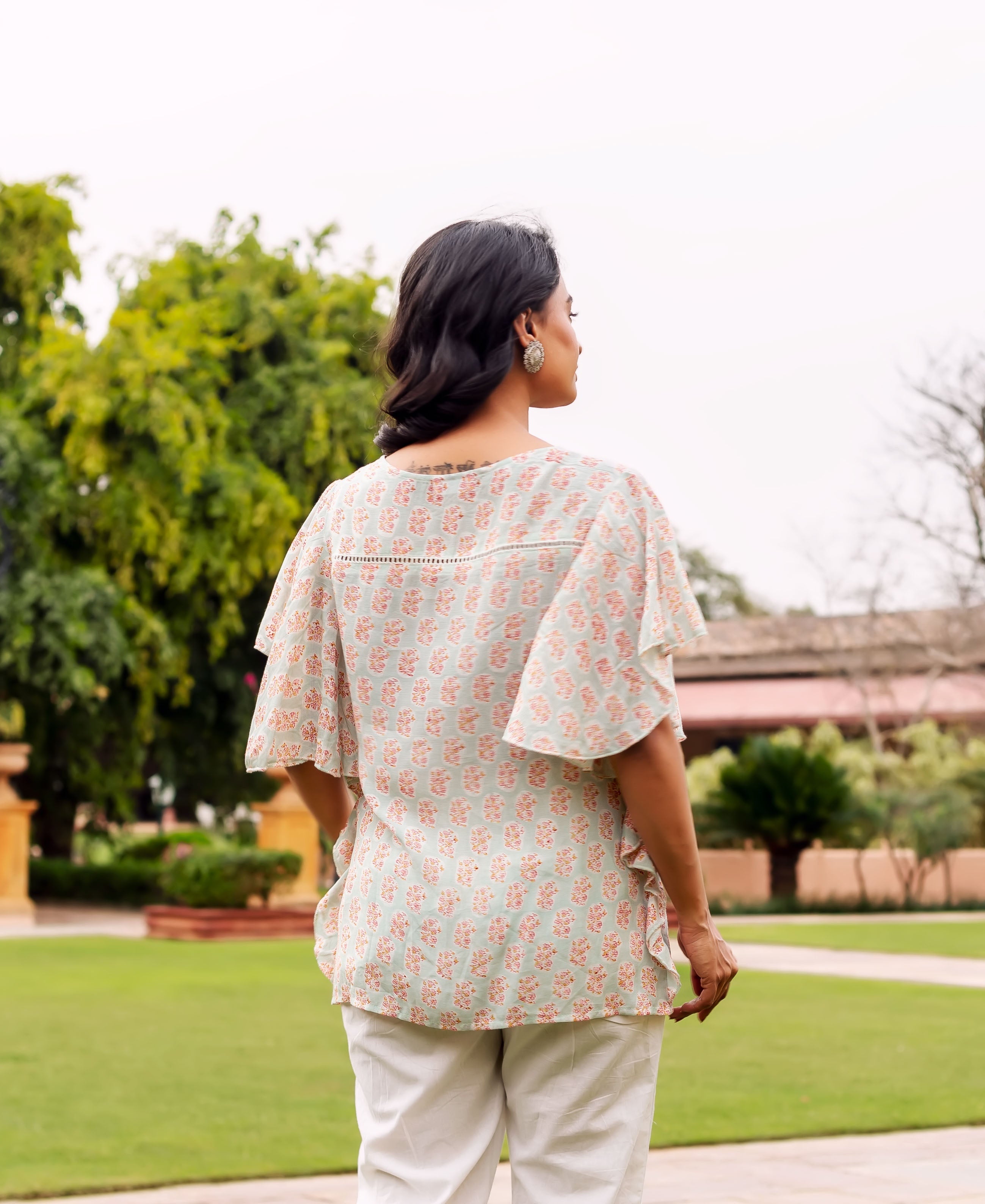 Mint green and peach hand-block-printed tunic with short ruffled sleeves, back view.