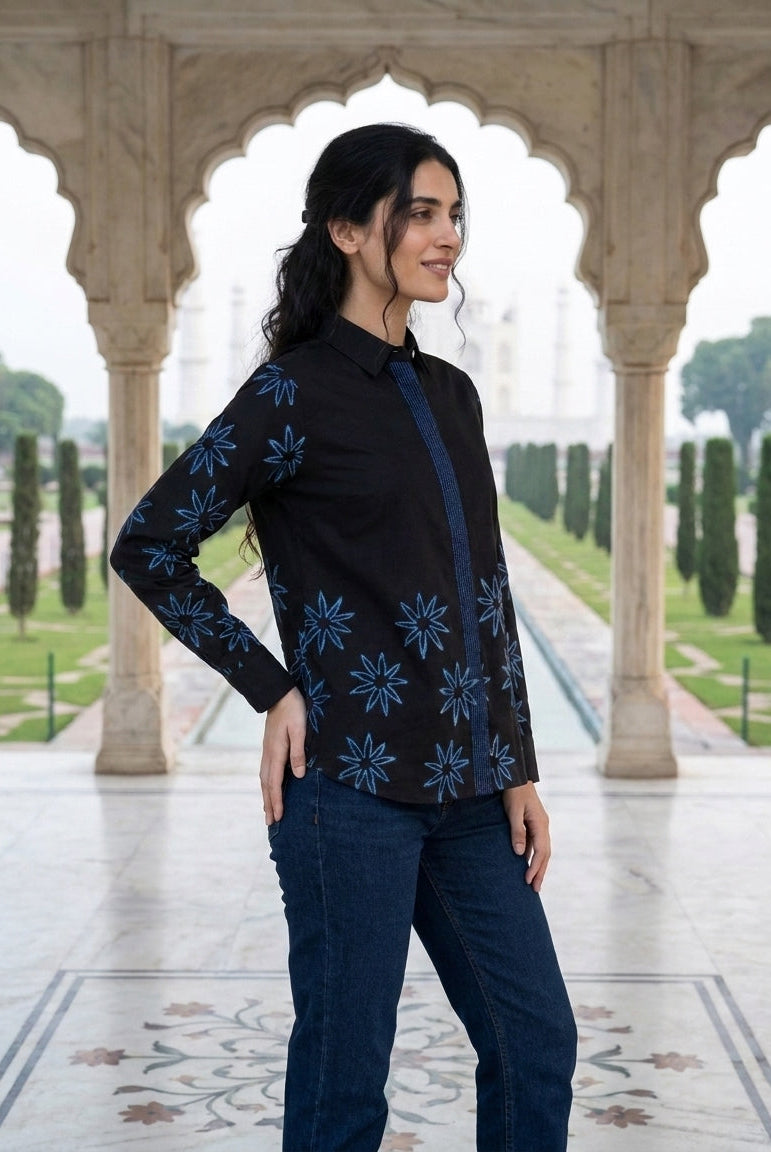 Side view of a model in a charcoal black cotton shirt with blue handblock star print.