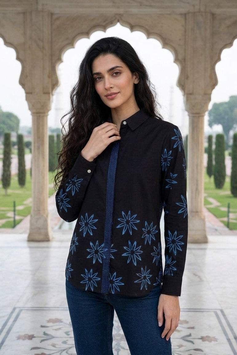 Model wearing a charcoal black handblock cotton shirt with blue star flower print.