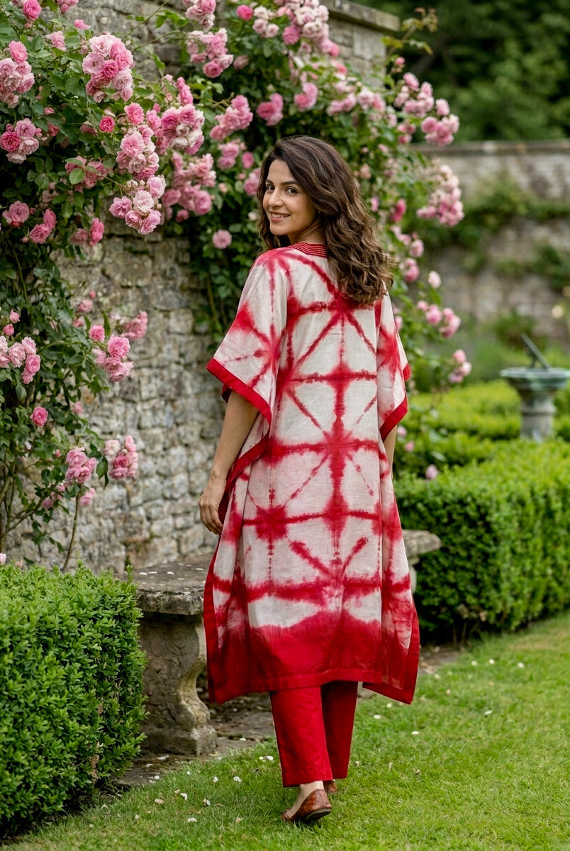Woman from behind wearing coral red and white tie-dye kaftan with red pants.
