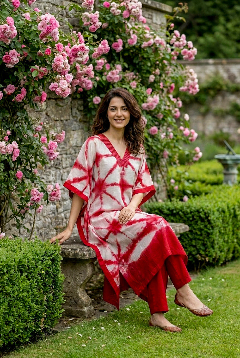 Front view of woman in coral red tie-dye kaftan and matching cotton pants.
