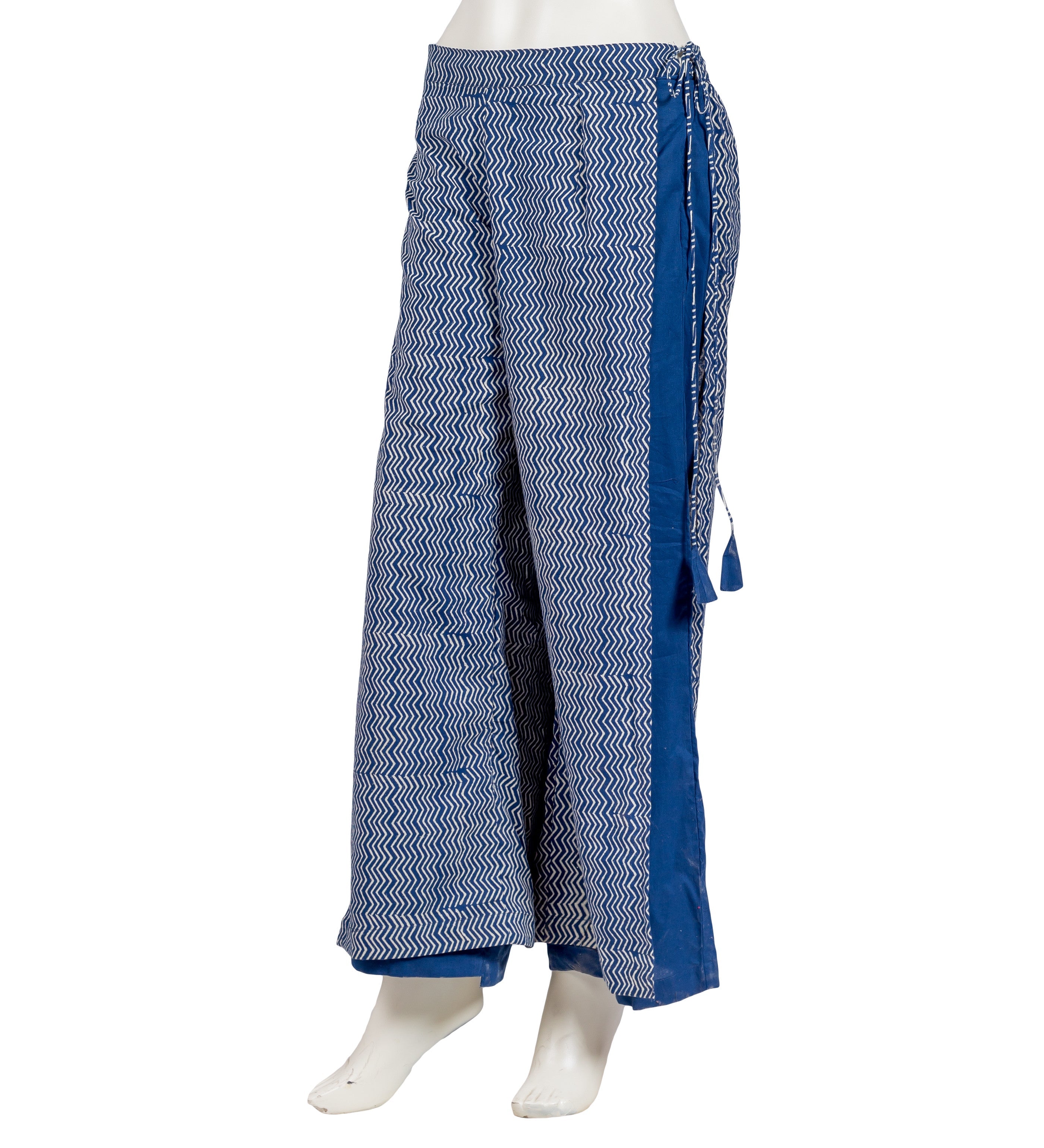 Side view of indigo blue wide-leg pants with white zigzag hand-block print and tassels.