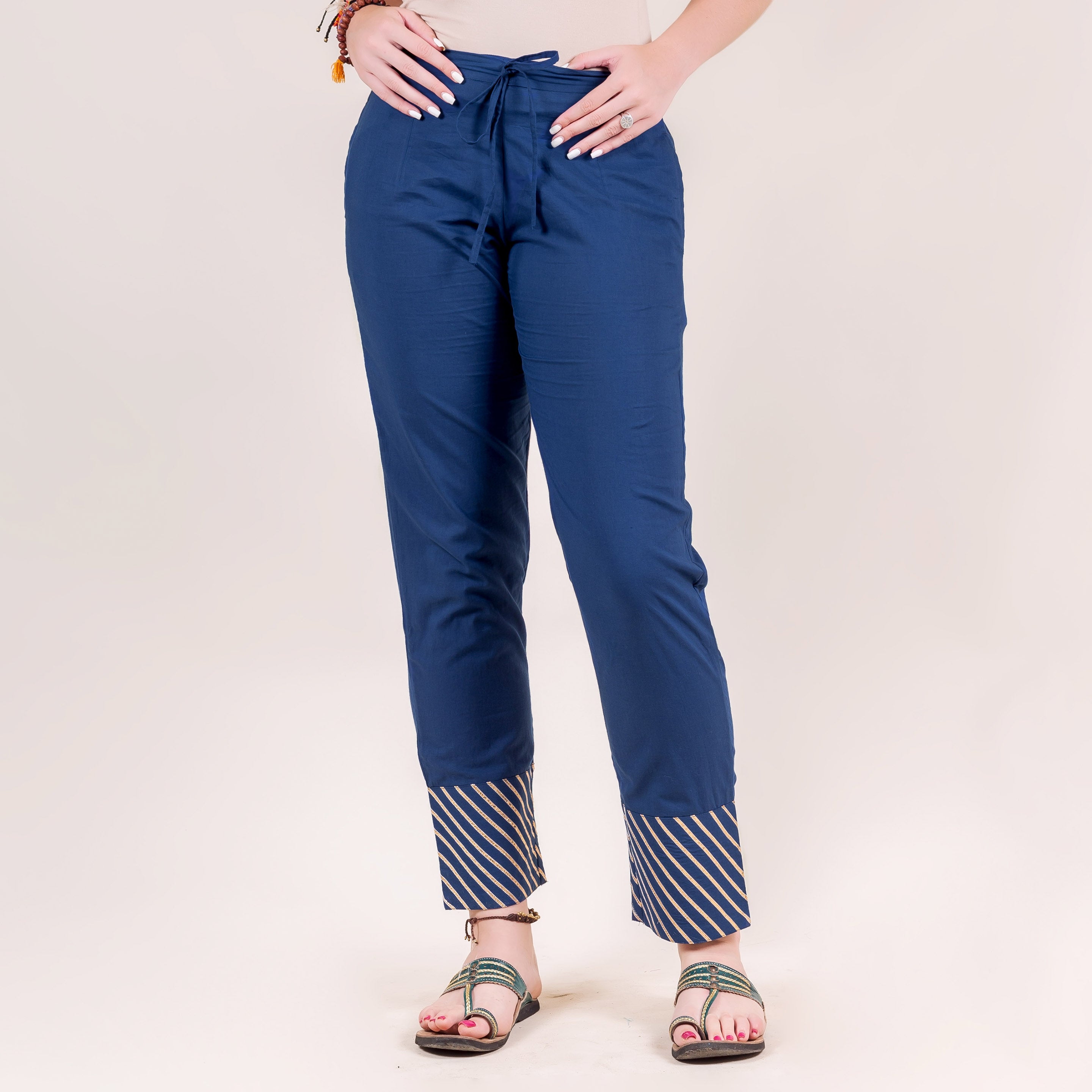 Indigo straight pants on model with diagonal striped cuffs and a drawstring waist.