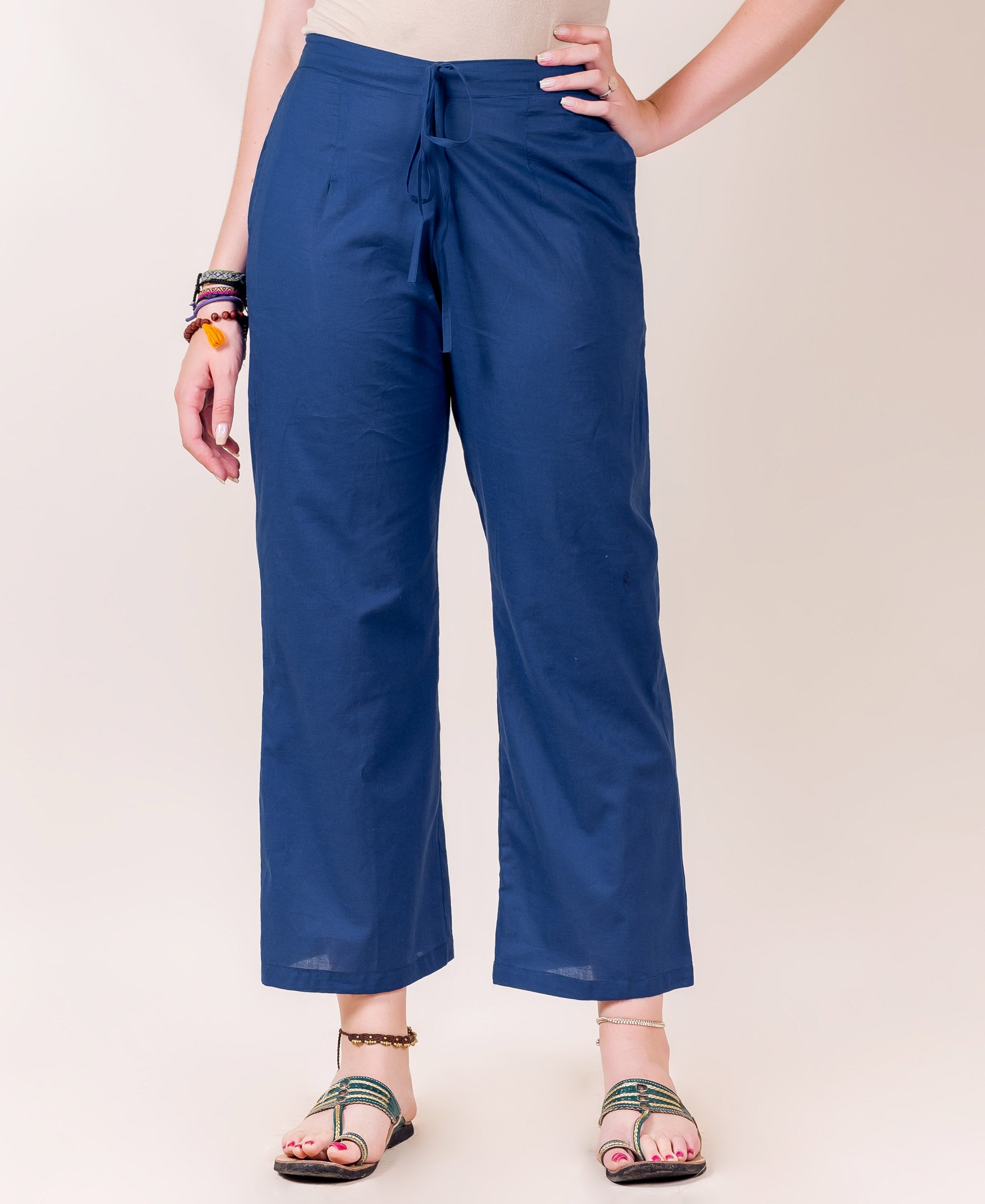 Model wearing solid indigo palazzo pants with a drawstring waist, cropped wide legs.