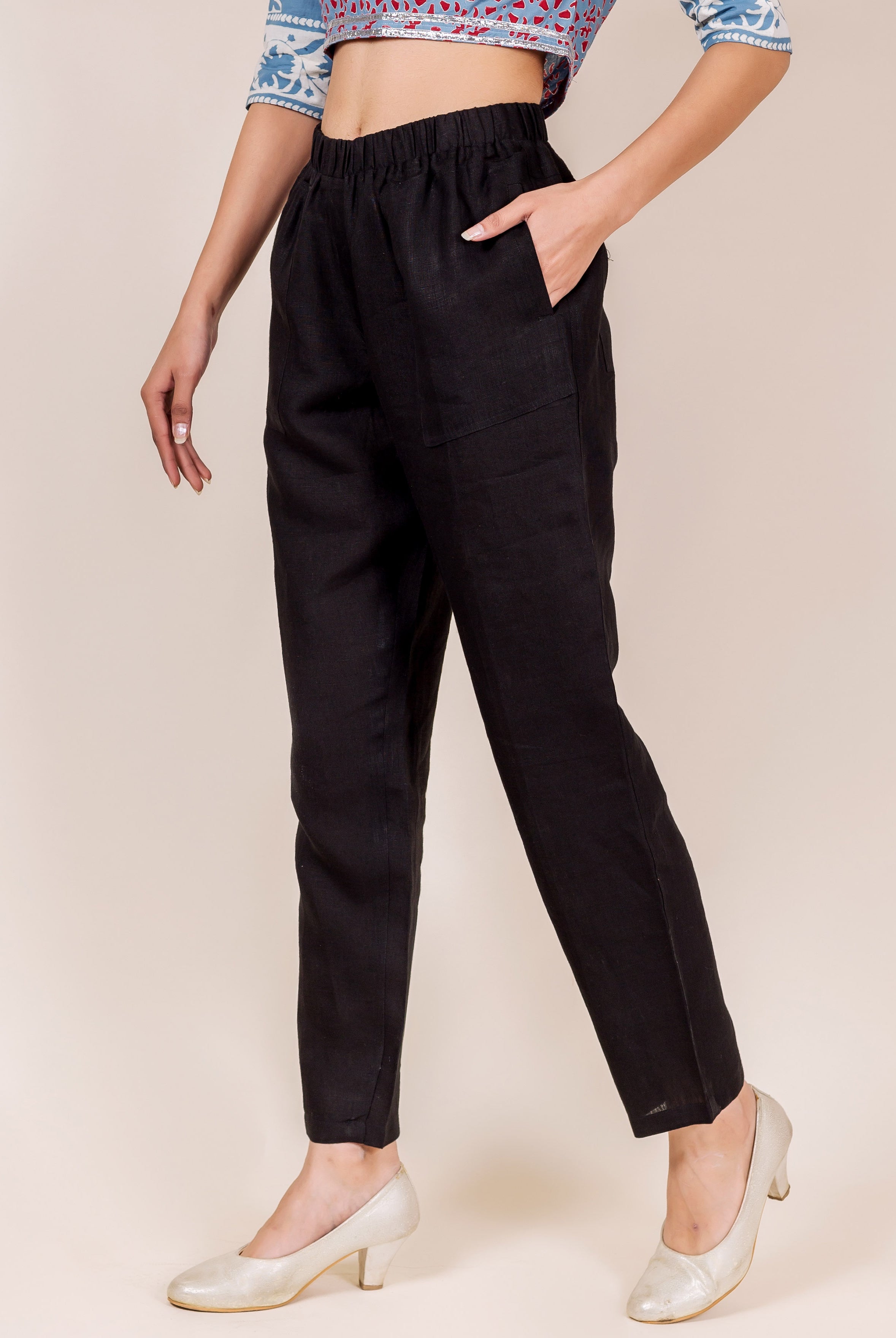 Black solid linen cropped pants on a model, with elasticated waist and pockets.