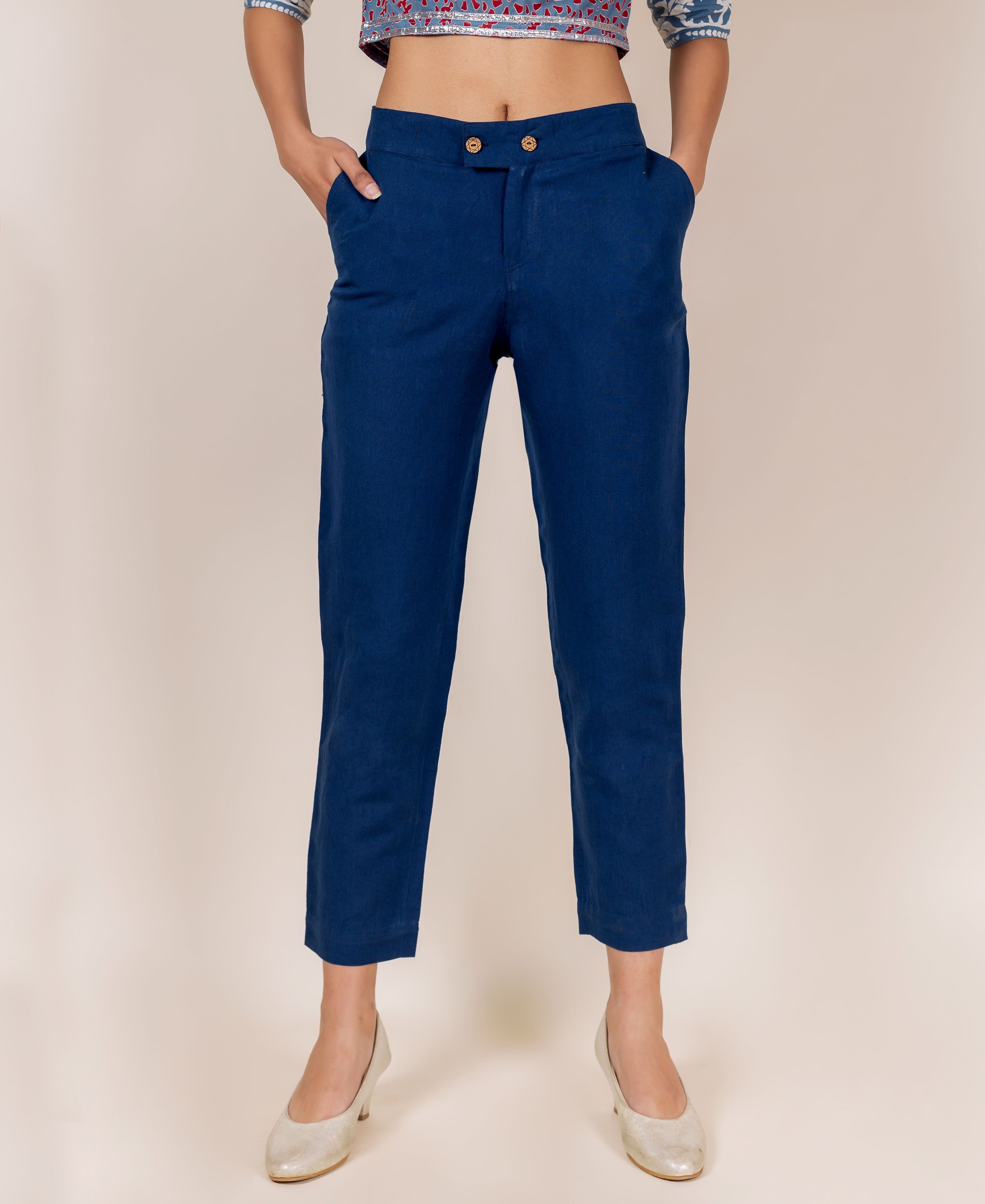 Front view of model wearing indigo blue solid narrow bottom pants with pockets.