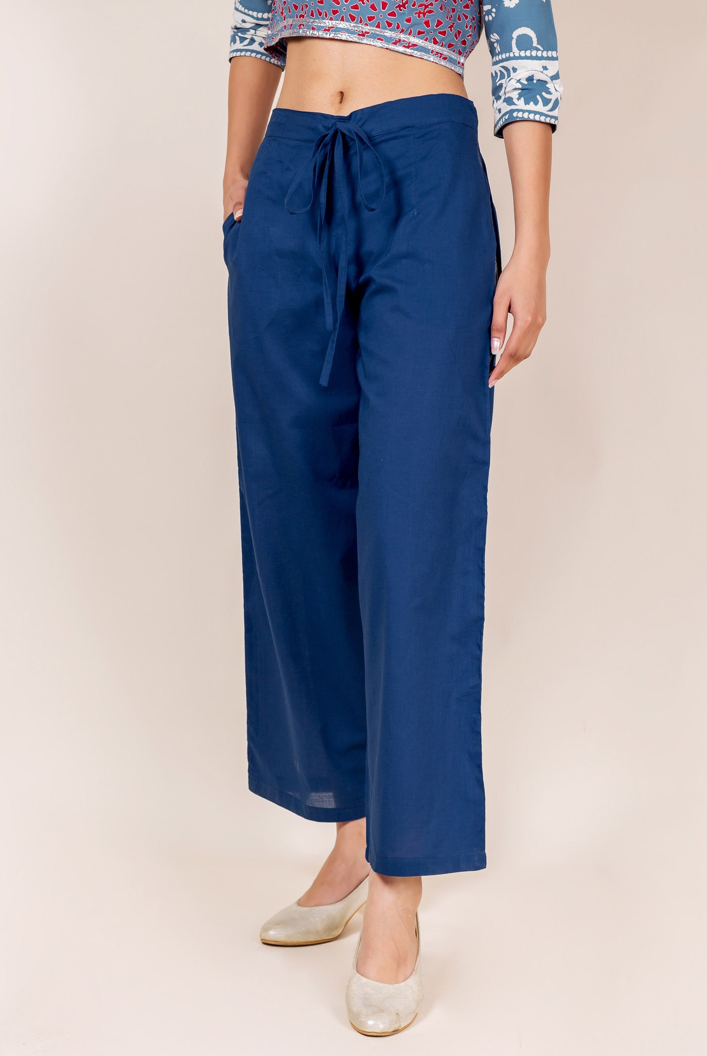 Front view of model wearing plain indigo cotton palazzo pants with drawstring waist.