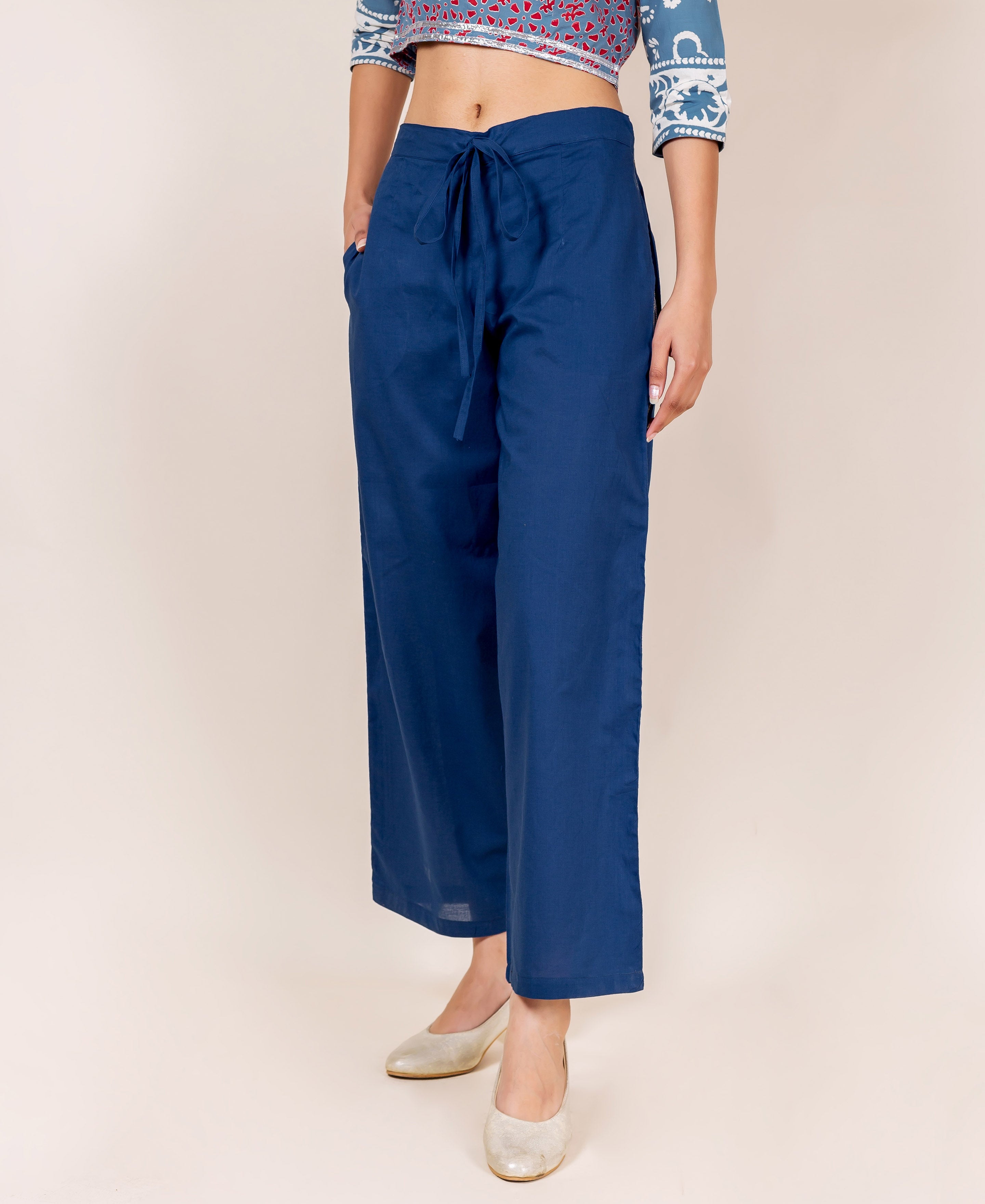 Front view of model wearing plain indigo cotton palazzo pants with drawstring waist.