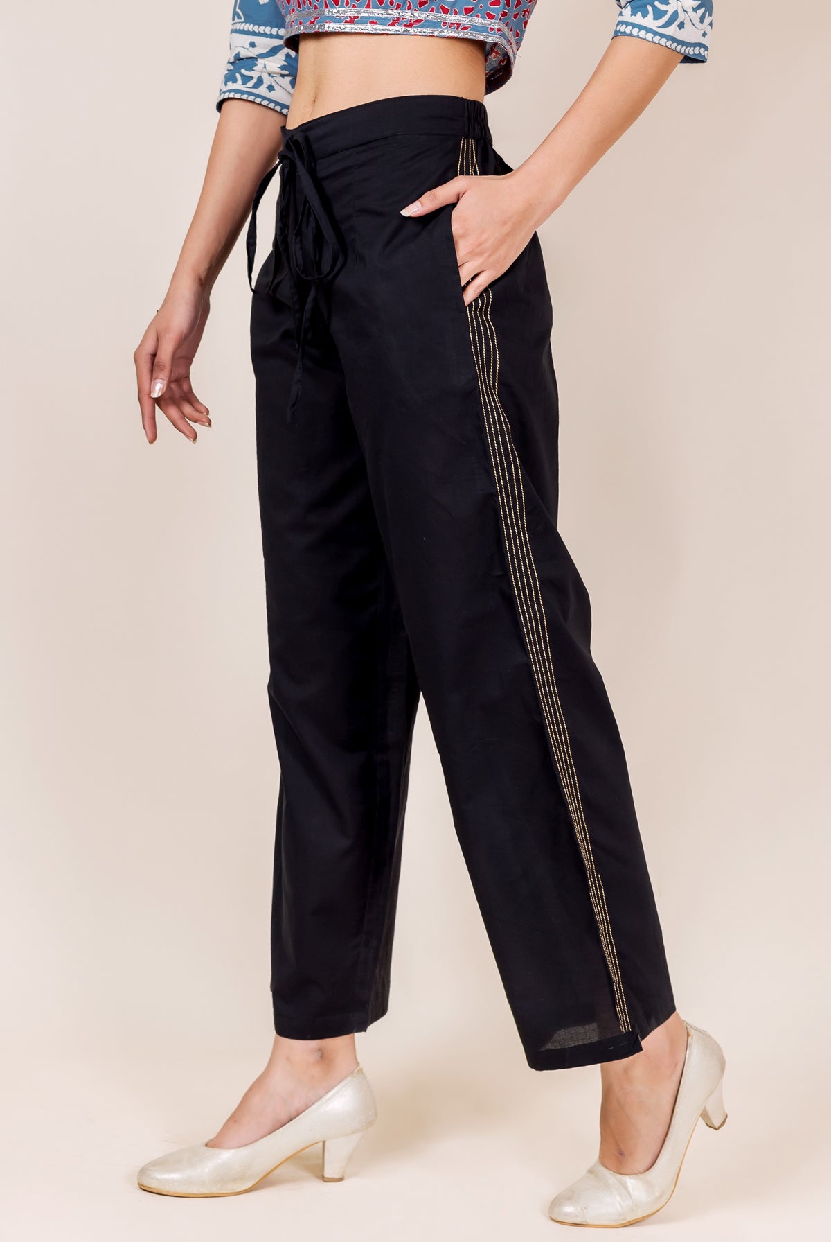 Black cotton palazzo pants with gold embroidery, worn by a model.