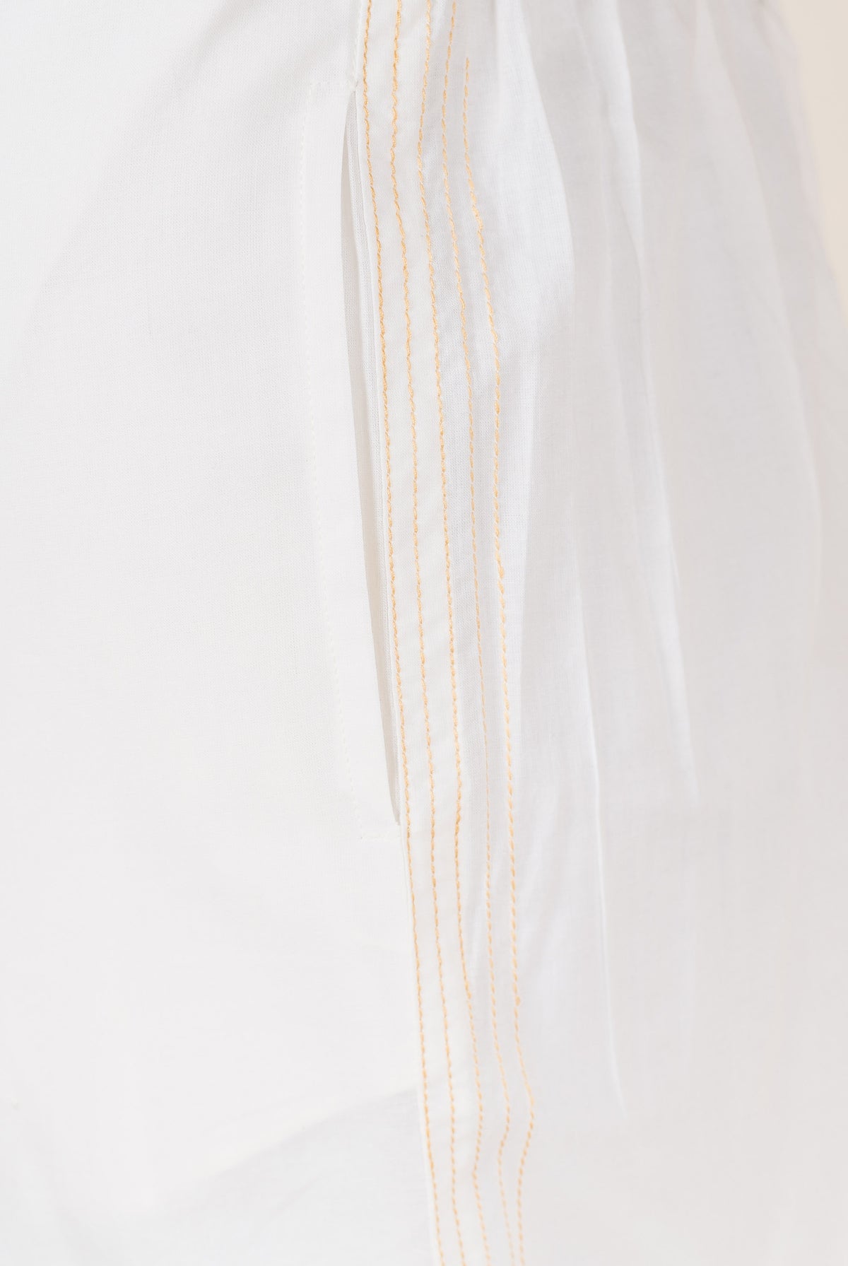 White palazzo pants with embroidered golden yellow stripes down the side.