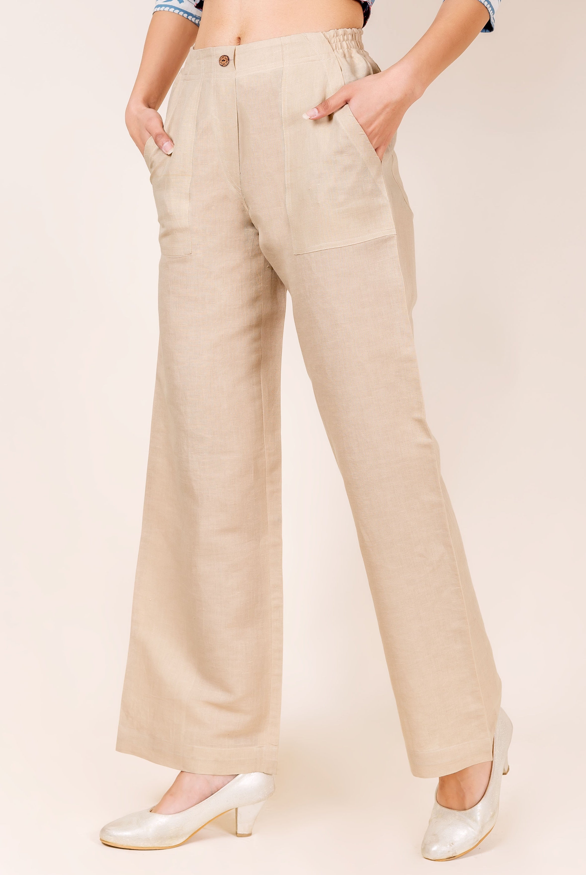 Front view of a model wearing full-length beige linen solid pants with pockets.