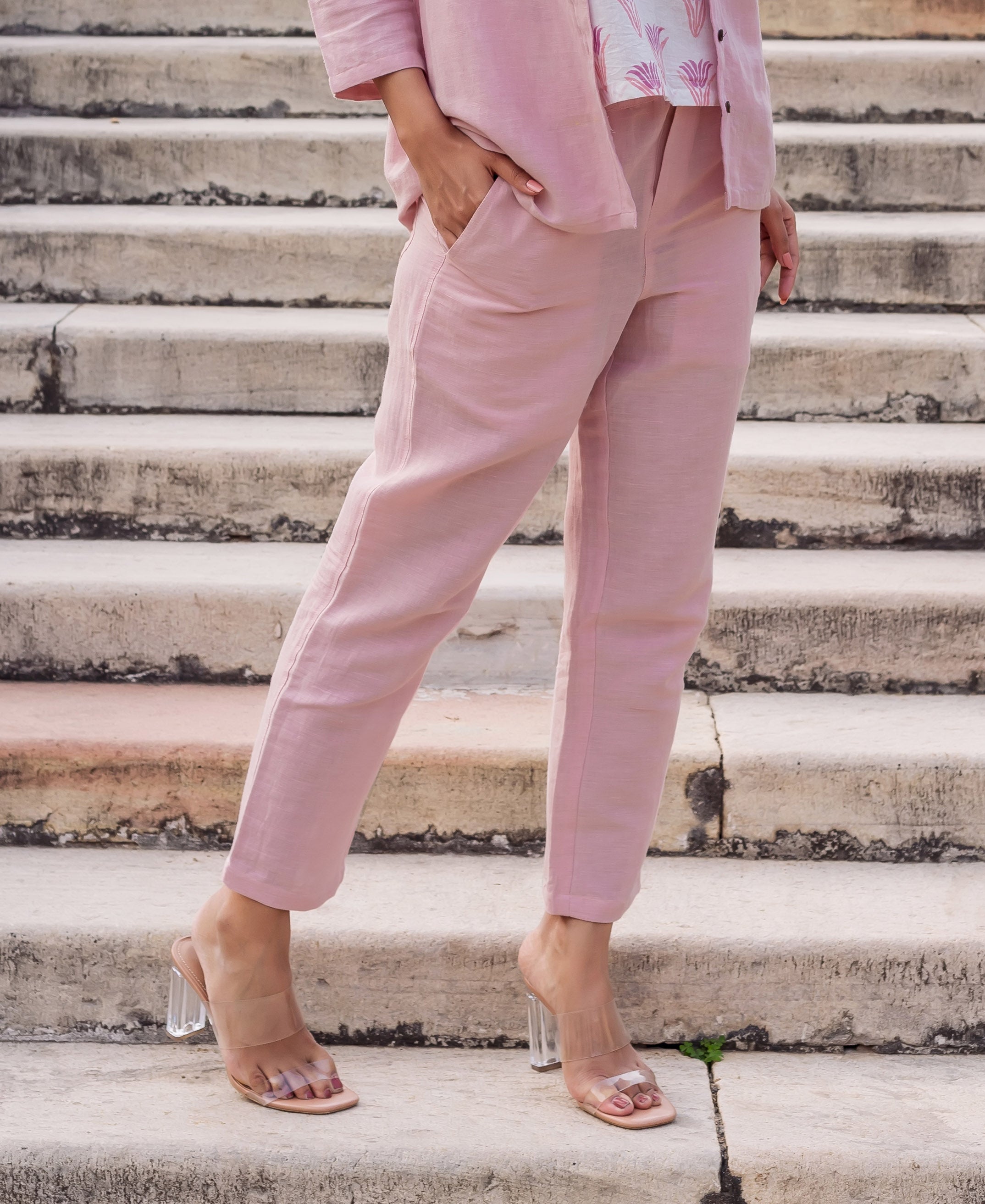 Front view of model wearing flamingo pink linen solid ankle-length pants.