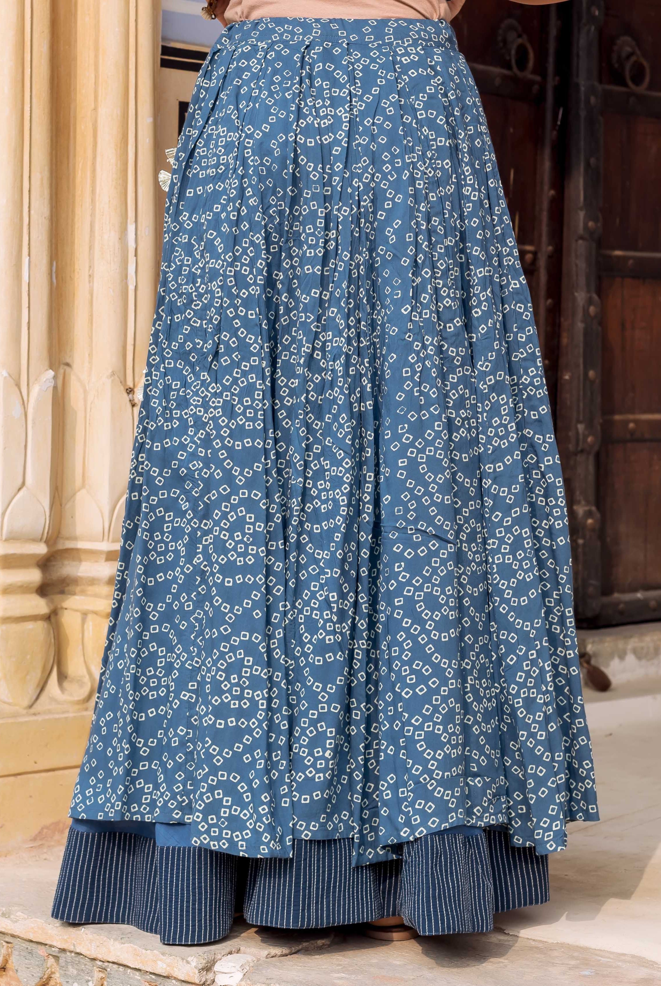 Front view of model wearing indigo blue Bandhej print skirt with striped underlayer.