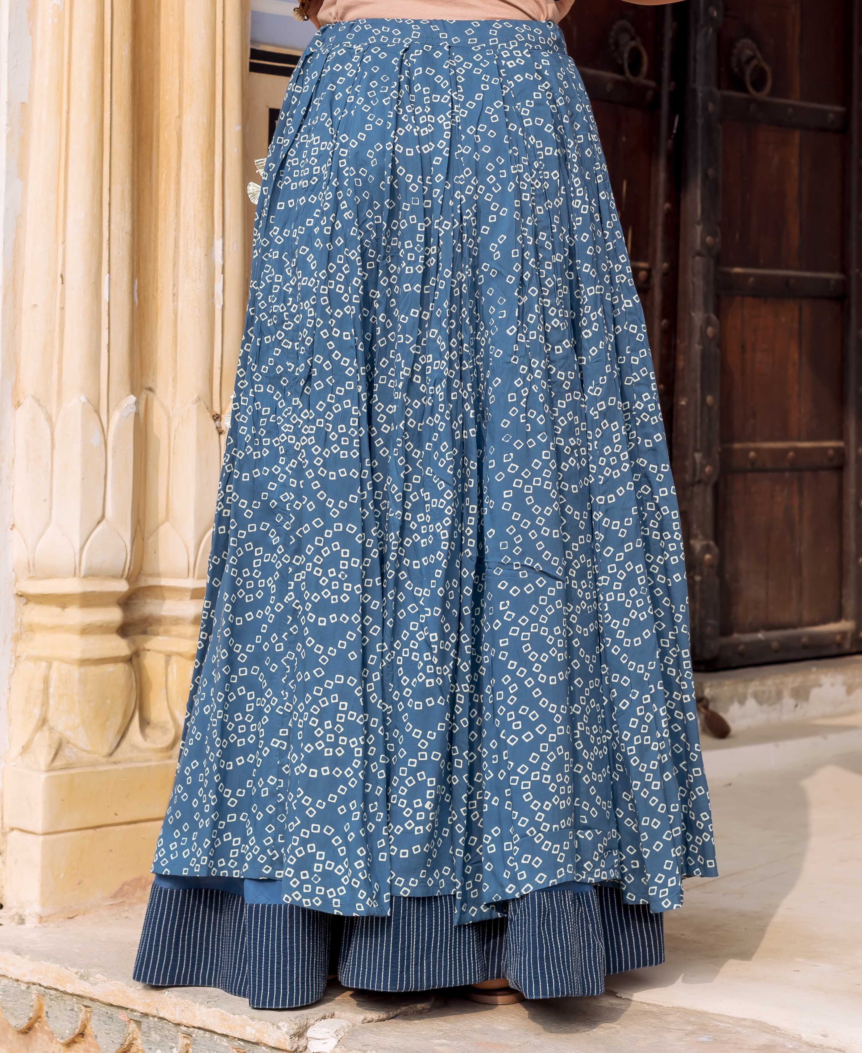 Front view of model wearing indigo blue Bandhej print skirt with striped underlayer.