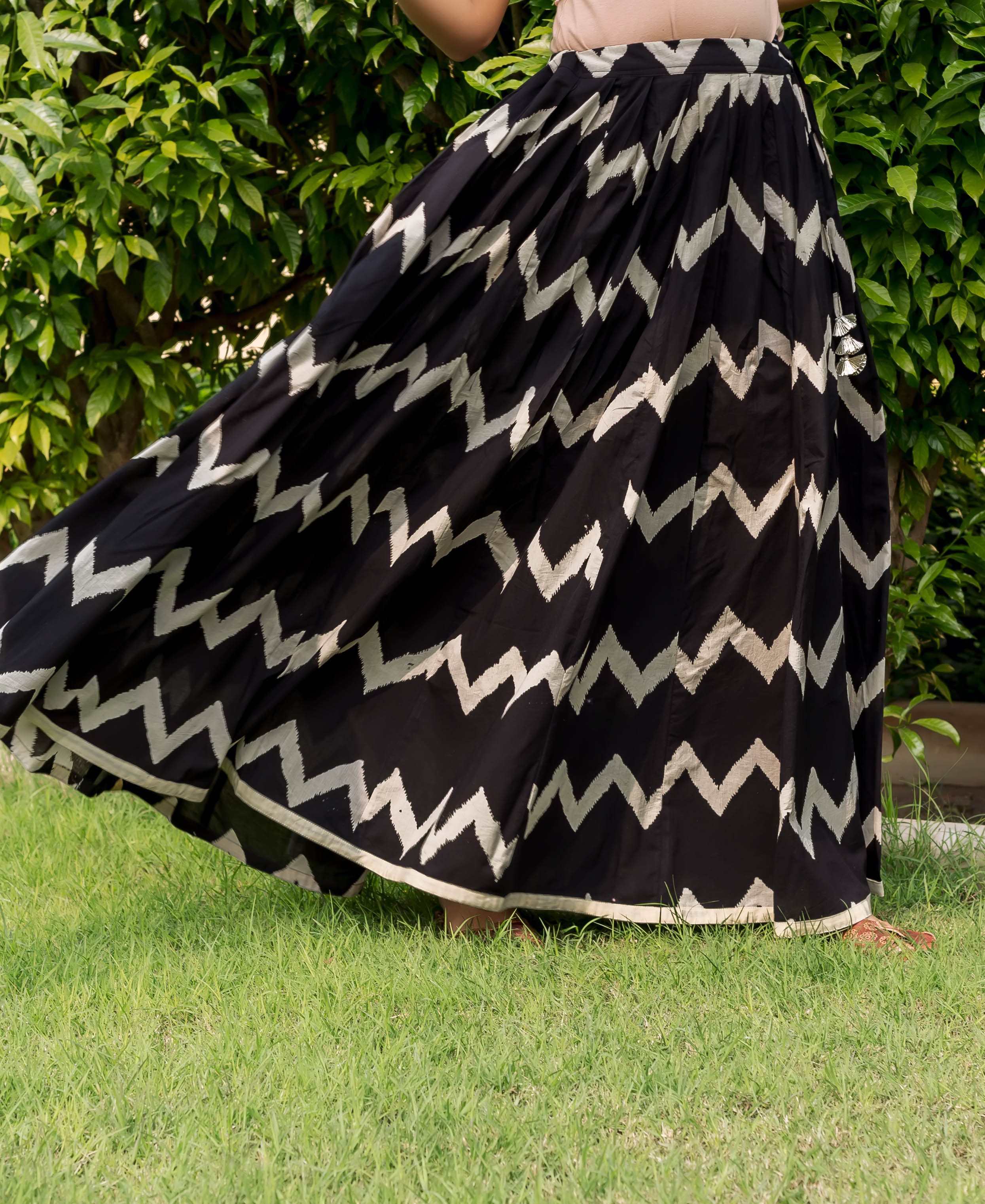 Flowing black ethnic hand-block print skirt with off-white zig-zag pattern and border on a model.