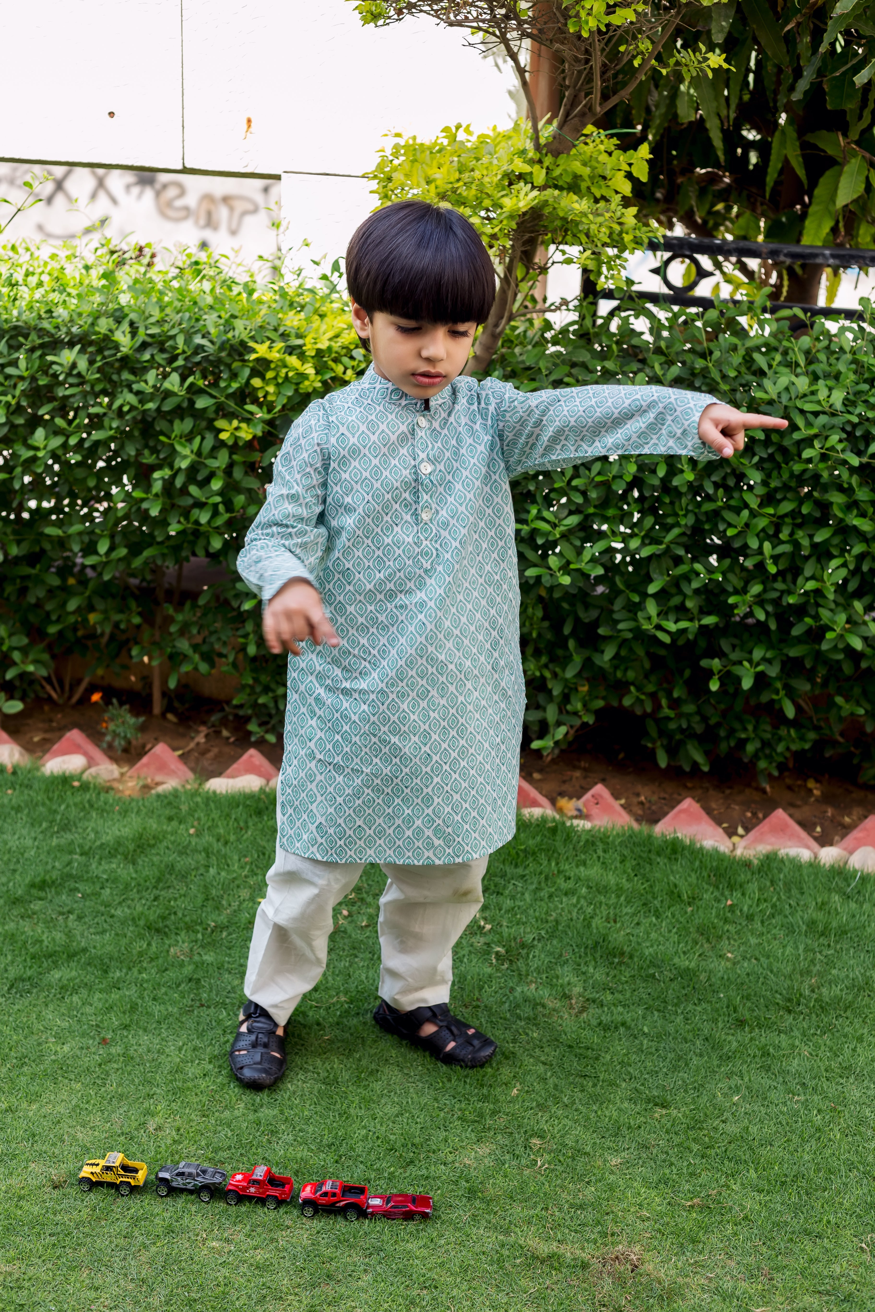 Young boy modeling light teal and white block printed kurta pajama set.