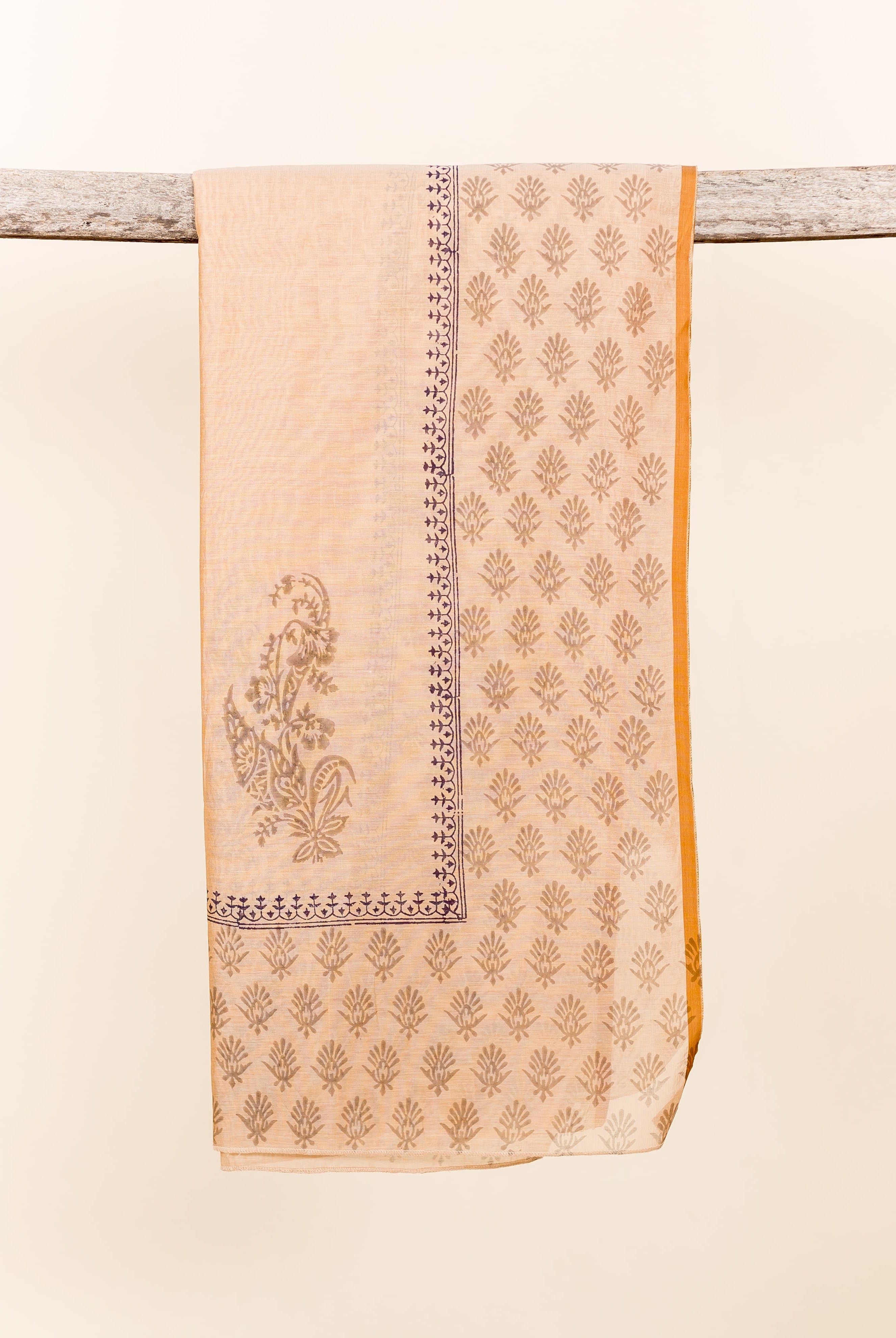 Beige chanderi dupatta with indigo block printed floral and paisley patterns, mustard border, draped.