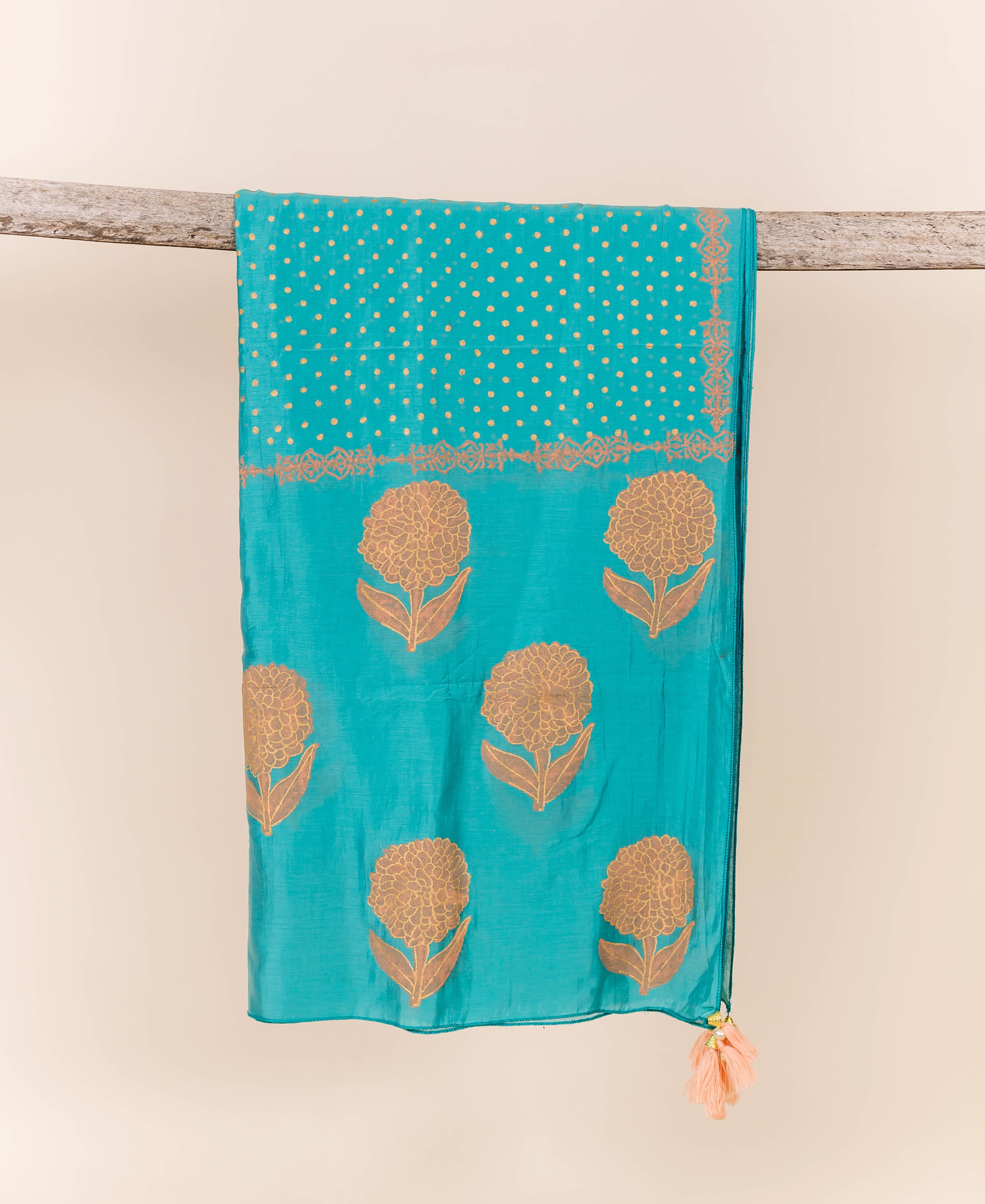 Flat-lay turquoise dupatta with peach block print and tassel.