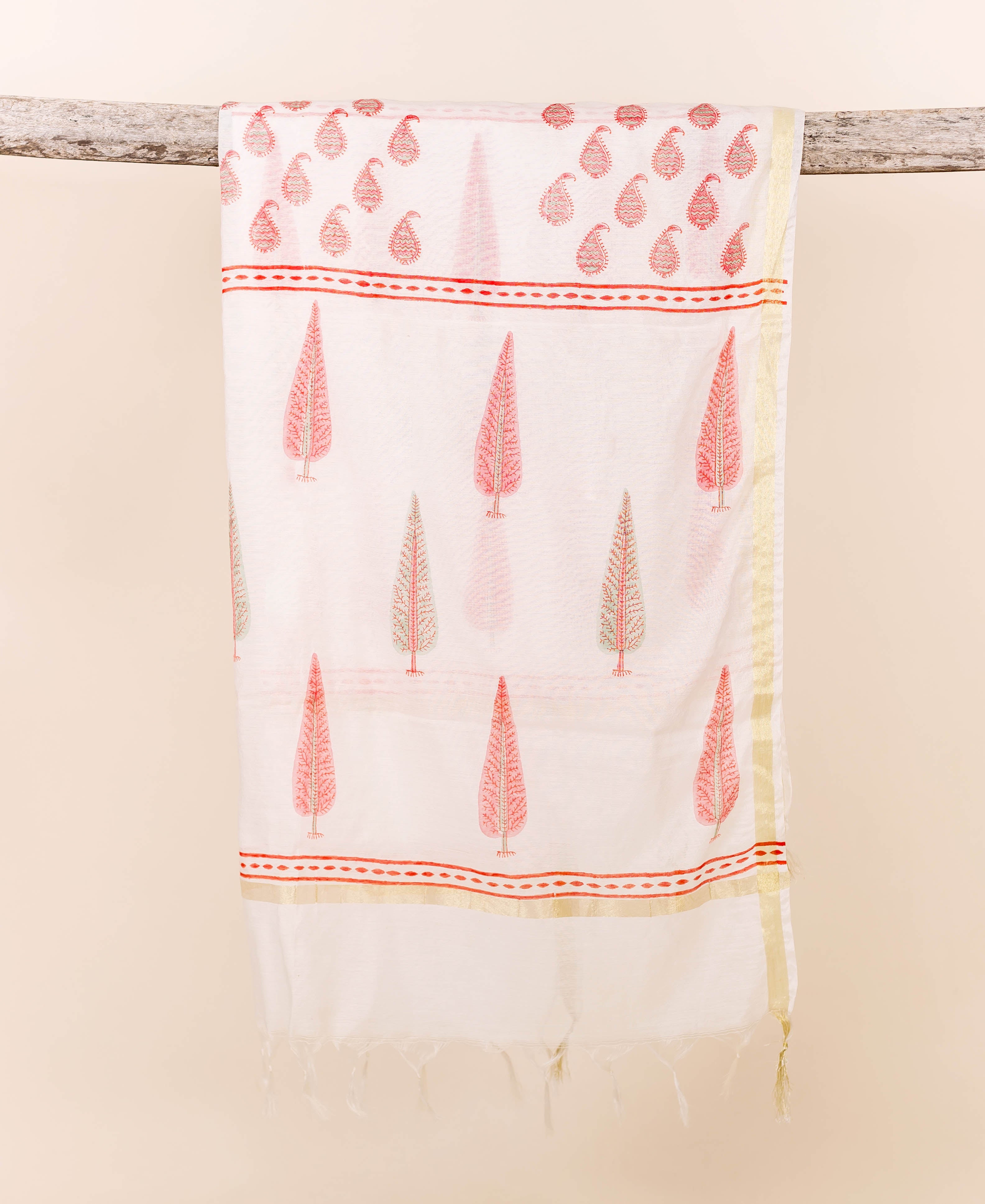 White Chanderi dupatta with pink paisley and tree block prints, draped on a branch.