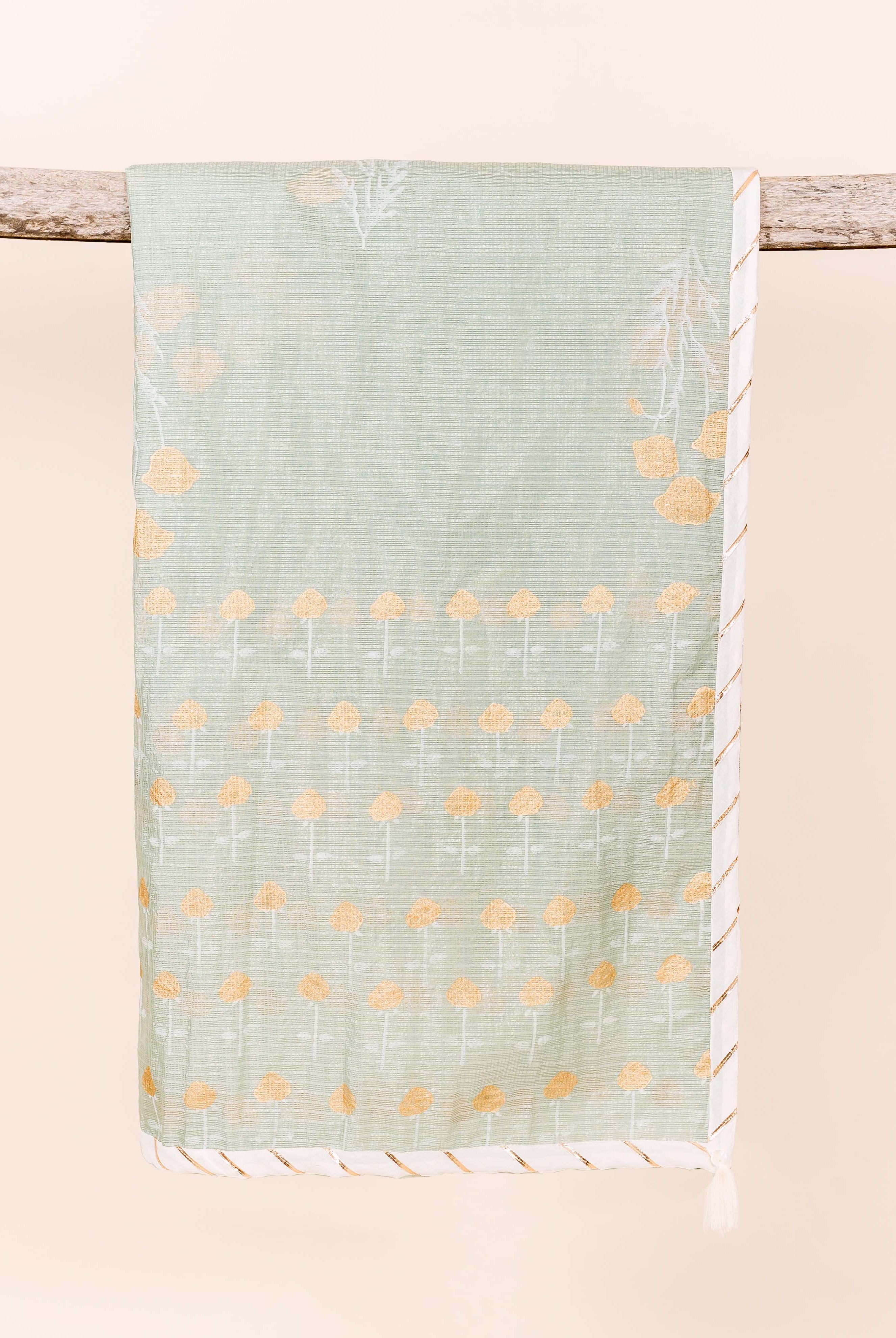 Muted green dupatta draped on wood, featuring yellow floral and white leafy block prints.